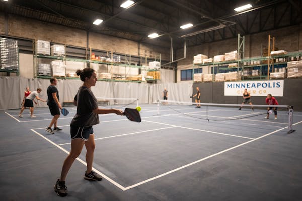 Kristina Reznikov served as she and Kurt Klenzman played a league game of pickleball at Minneapolis Cider Co. in July 2021