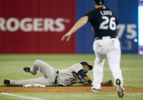Toronto Blue Jays Adam Lind (26) runs safely to second as Minnesota Twins shortstop Alexei Casilla dives and misses the ball during fifth inning baseb