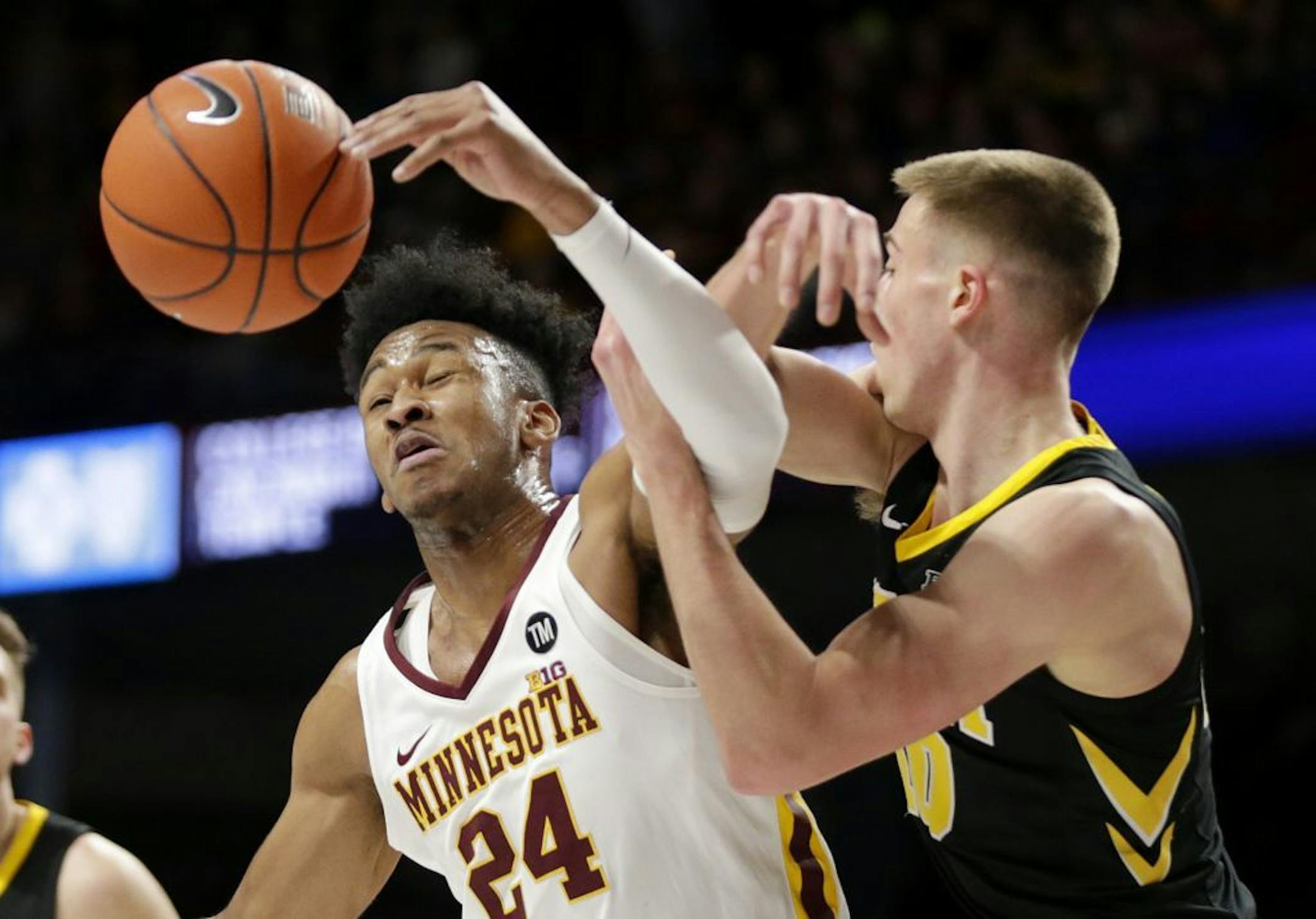 Iowa guard Joe Wieskamp (10) and Minnesota forward Eric Curry (24) vie for the ball during the first half of an NCAA college basketball game Sunday, Jan. 27, 2019, in Minneapolis.