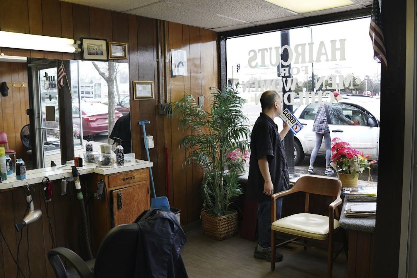 Mike Stevenson flipped his barber shop sign to closed after learning state regulators had clarified that hair and nail salons, spas and other similar businesses are included in Minnesota Gov. Tim Walz's order to cease operations Wednesday, March 18, 2020 in Columbia Heights, Minn.