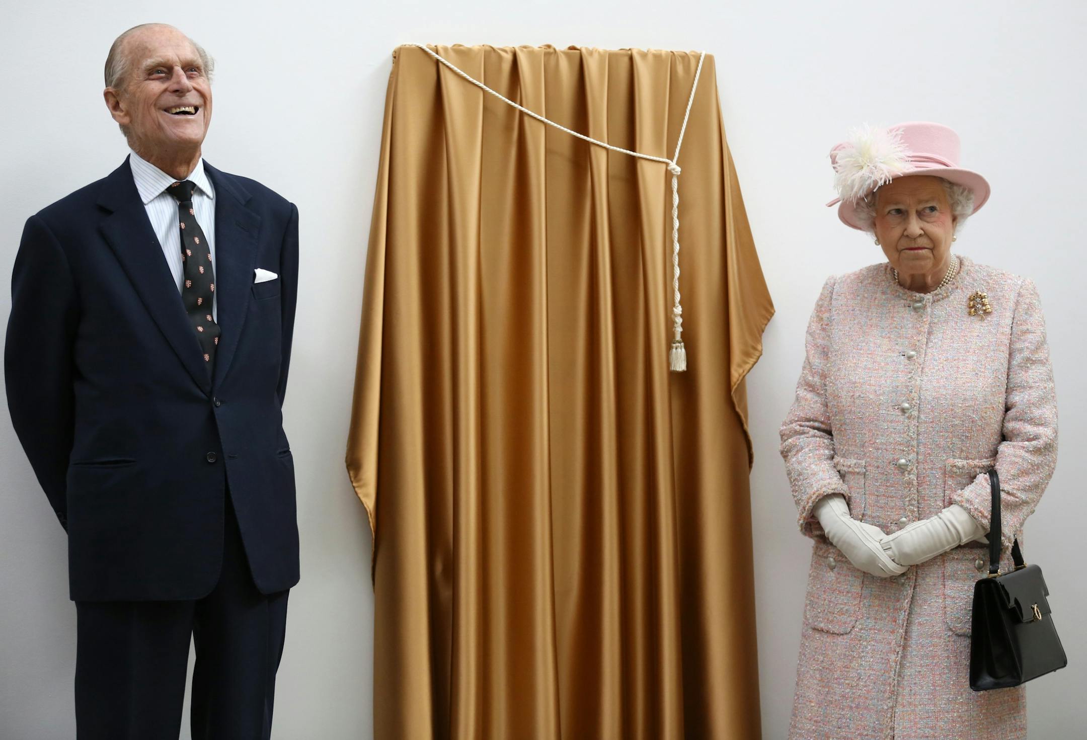 Britain's Queen Elizabeth II and Prince Philip, The Duke of Edinburgh, during a visit to the Medical Research Council in Cambridge, England, Thursday, May 23, 2013.
