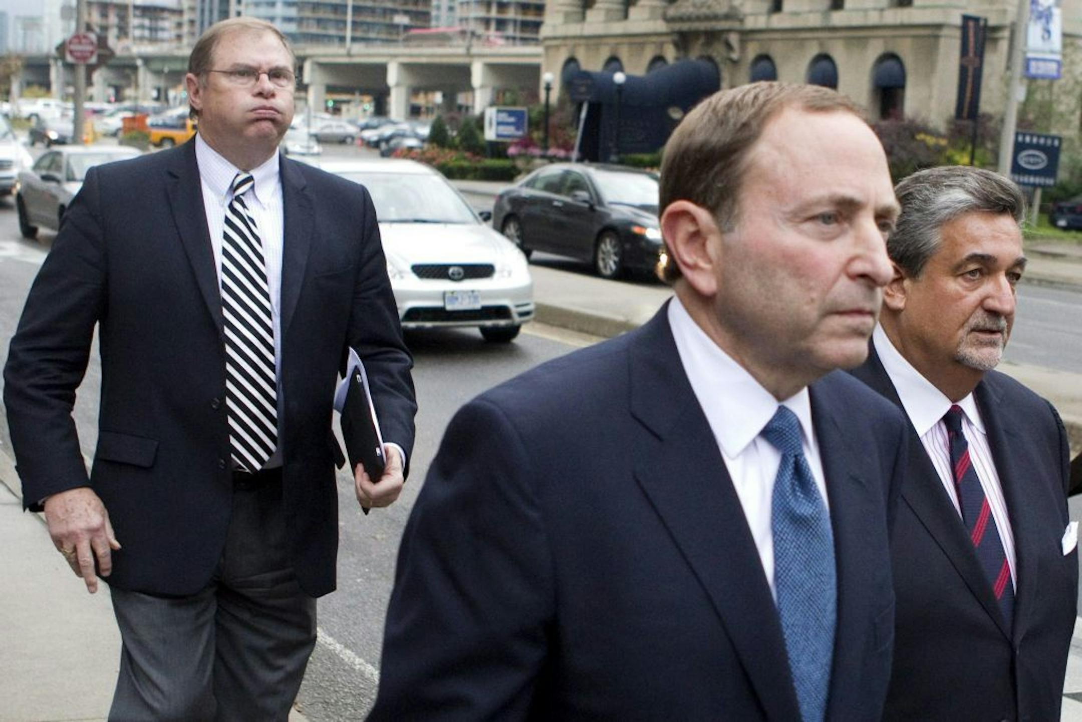Craig Leipold, left, owner of Minnesota Wild, follows NHL Commissioner Gary Bettman, center, and Washington Capitals owner Ted Leonsis, right, leaves the NHLPA's following collective bargaining in Toronto on Thursday, Oct. 18, 2012. (AP Photo/The Canadian Press, Chris Young) offices with