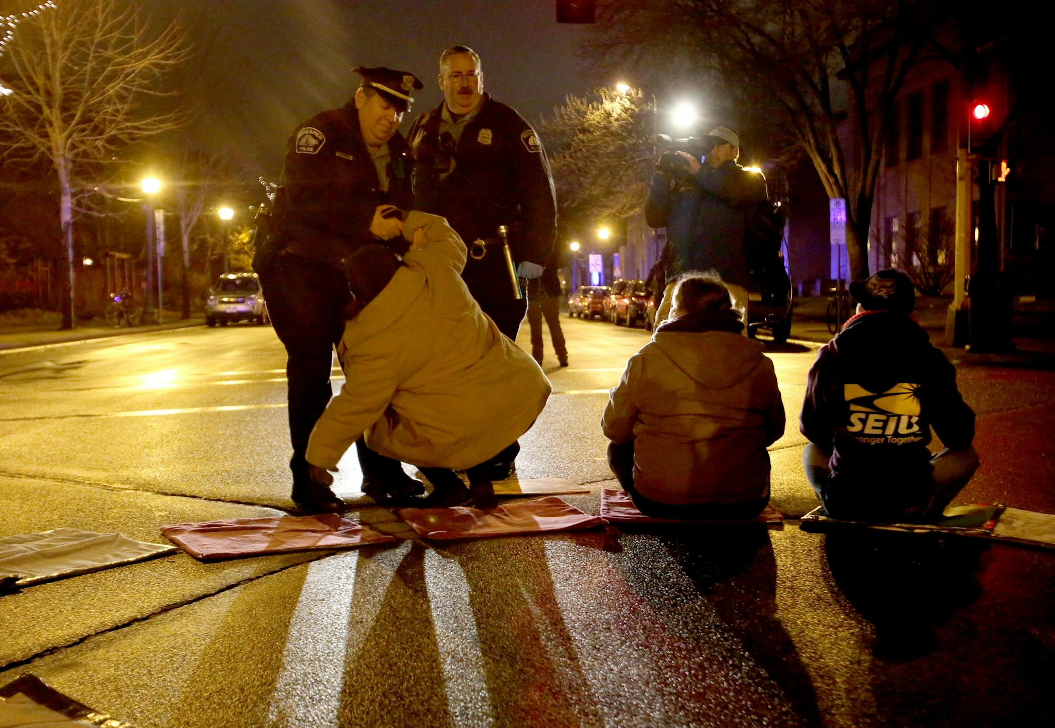 Protestors for Nationwide Fight for $15 Day of Disruption gathered outside McDonald's at 24th St. E. and Franklin Avenue, where for about a half hour protestors sat in a circle and blocked the intersection until they were arrested by Minneapolis police Tuesday, Nov. 29, 2016, in Minneapolis, MN. Here, man is taken into police custody as protestors blocked the intersection.