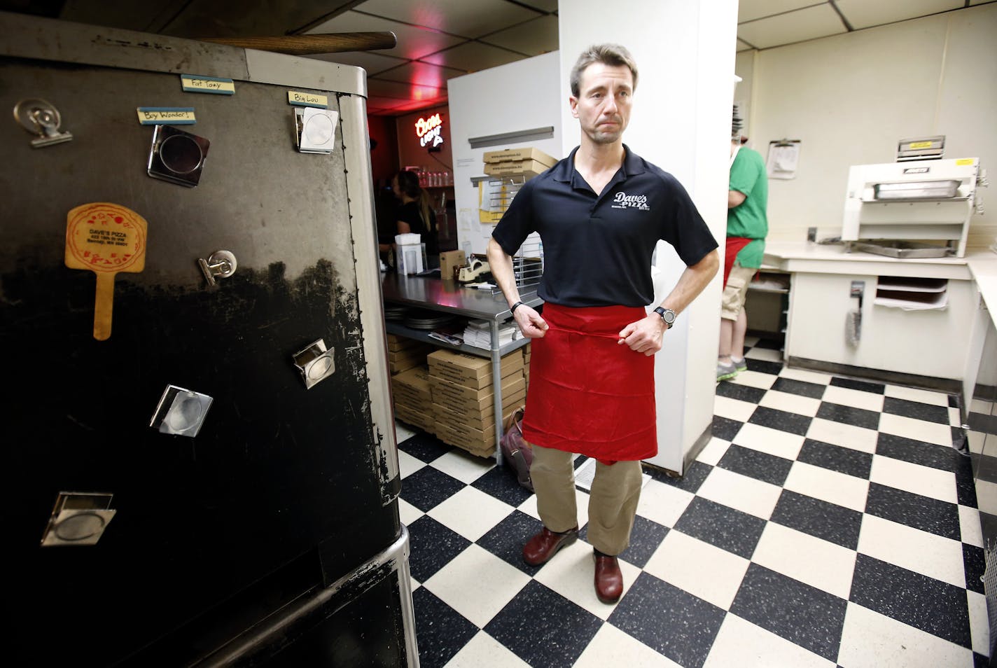 Pete Fenson owner of Dave's Pizza in Bemidji, Minn put on an apron before opening up. Fenson and his team won a Bronze medal in the 2006 Winter Olympics. It was the first Olympic medal for the United States in curling.