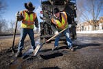 Street service workers Bradley Therres, left, and Lance Hamby fill potholes on Shepard Road.