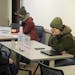 Amber Ruth, right, a mental health practitioner with the St. Paul Police Community Outreach and Stabilization Team, works with the public at St. Paul�