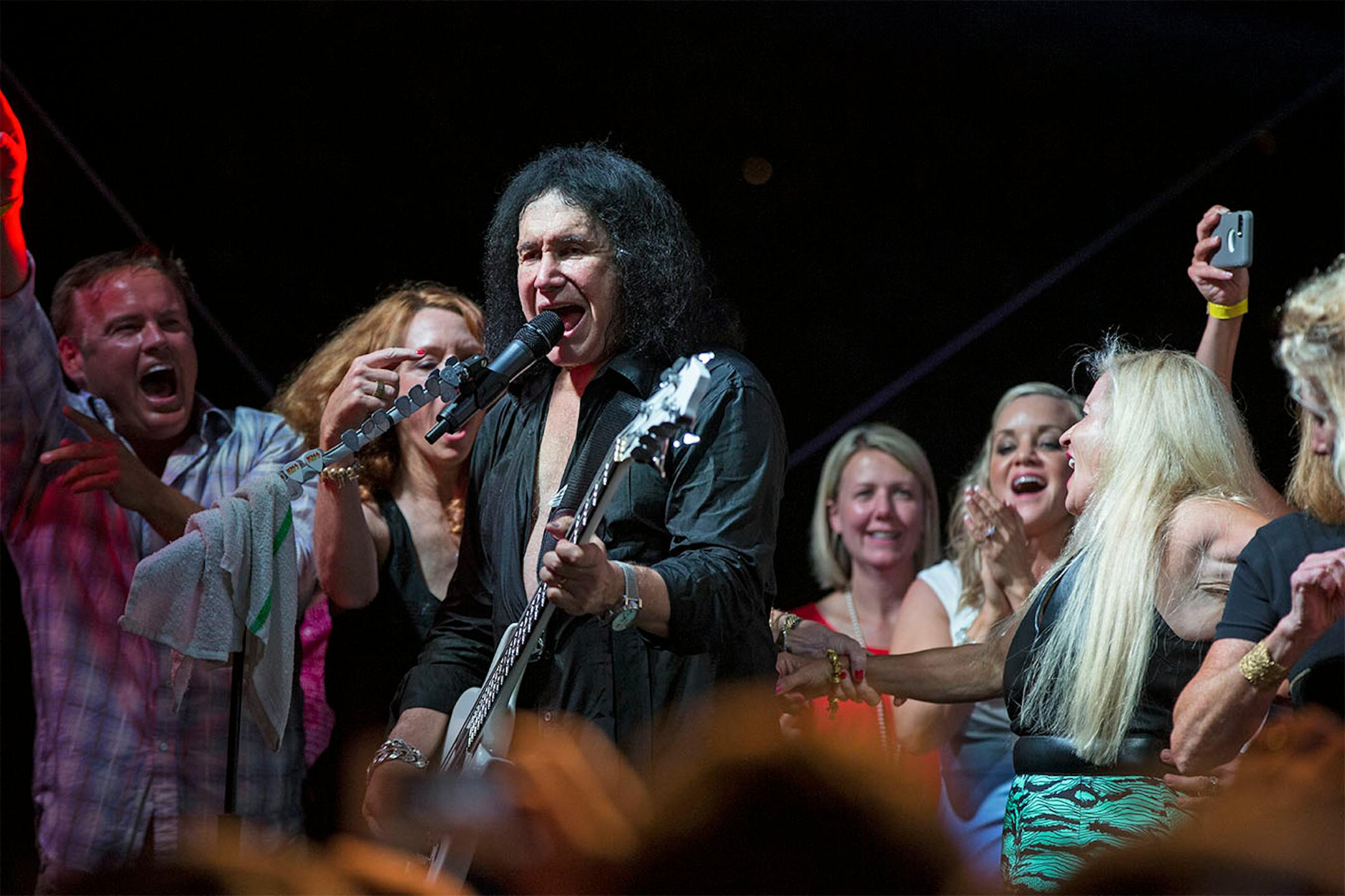 Members of the crowd came on stage with Kiss (Gene Simmons in this picture) as they performed their final song "I'm wanna to Rock N Roll all night" during a charity concert at philanthropist Martha "Muffy" MacMillan's home on Tuesday, August 2, 2016, in Long Lake, Minn.
