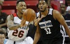 Portland Trail Blazers' Malcolm Thomas passes around Minnesota Timberwolves&#x2019; Karl-Anthony Towns during the first half of an NBA summer league b