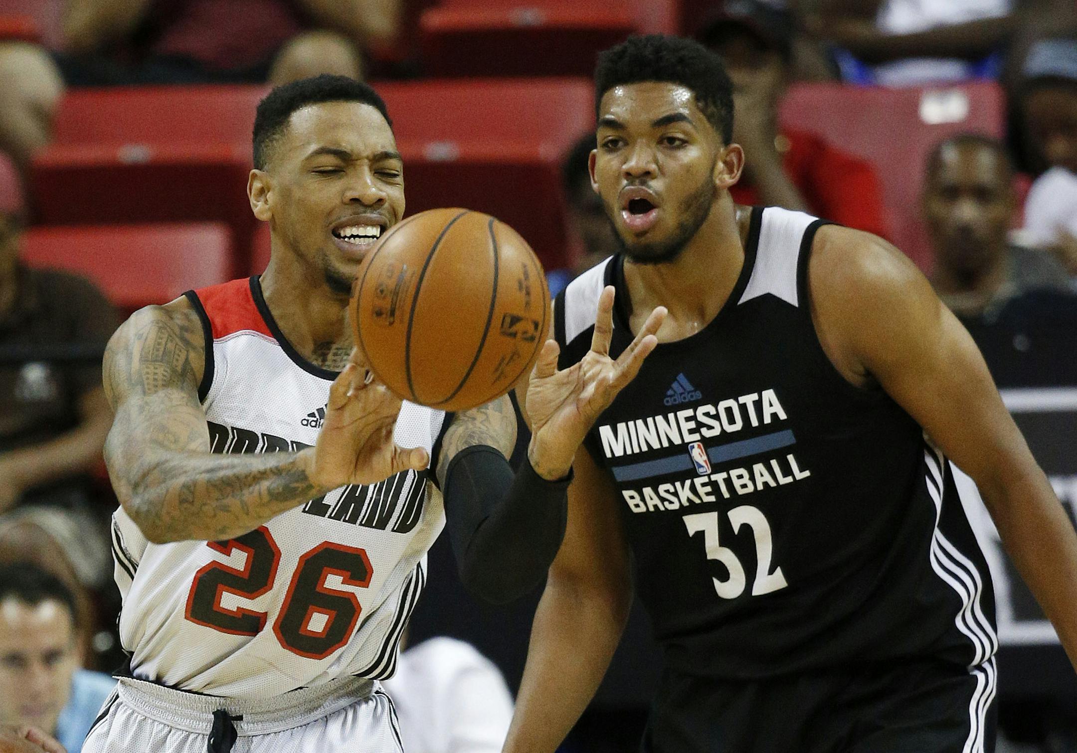 Portland Trail Blazers' Malcolm Thomas passes around Minnesota Timberwolves’ Karl-Anthony Towns during the first half of an NBA summer league basketball game Wednesday, July 15, 2015, in Las Vegas. (AP Photo/John Locher)