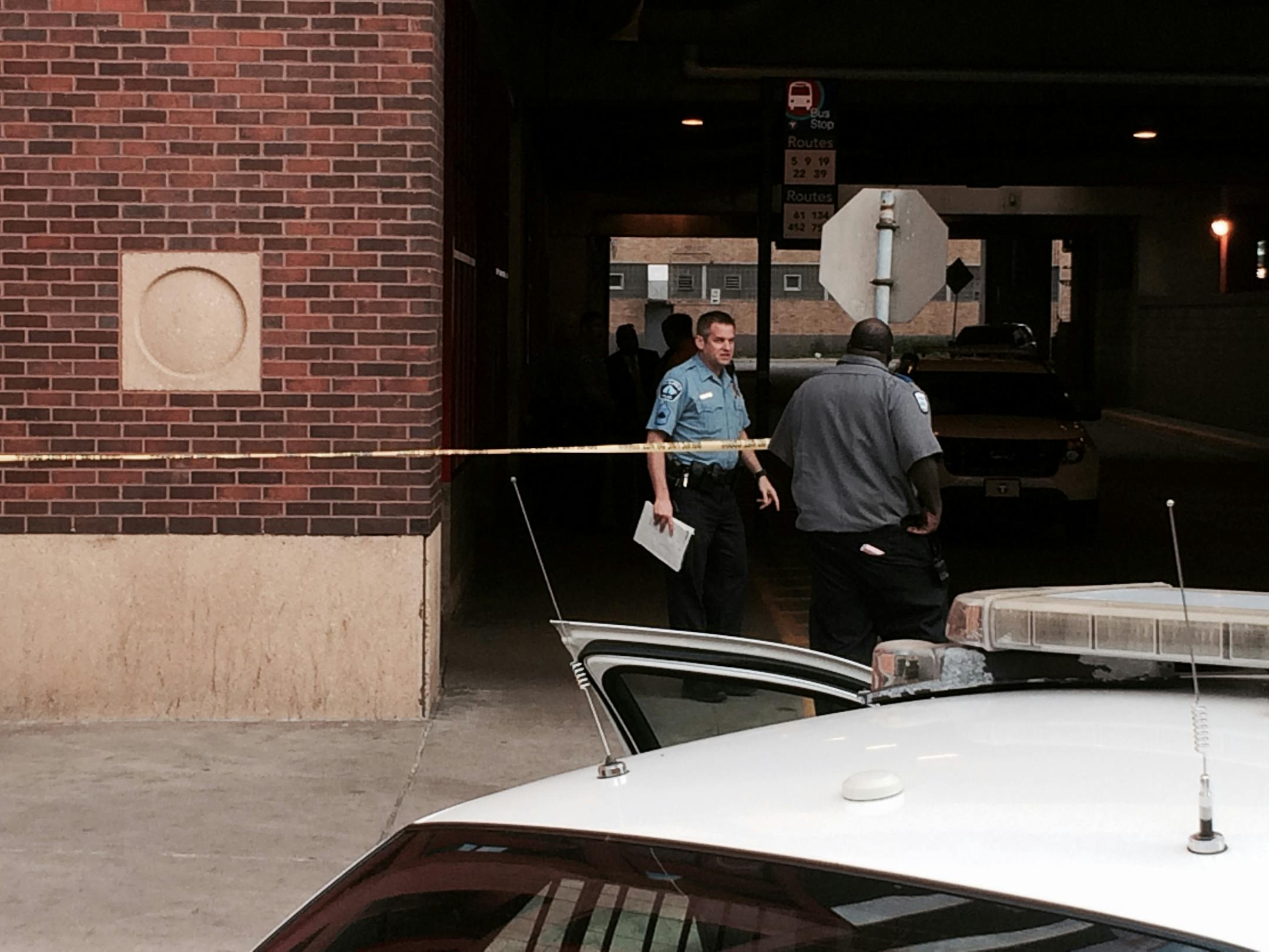 A Minneapolis police officer talks with a security guard at the scene of a fatal stabbing Thursday morning.