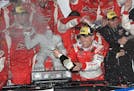 Kevin Harvick celebrates with champagne in Victory Lane after he won the NASCAR Sprint Cup series auto race, Sunday, Oct. 4, 2015, at Dover Internatio