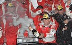 Kevin Harvick celebrates with champagne in Victory Lane after he won the NASCAR Sprint Cup series auto race, Sunday, Oct. 4, 2015, at Dover Internatio