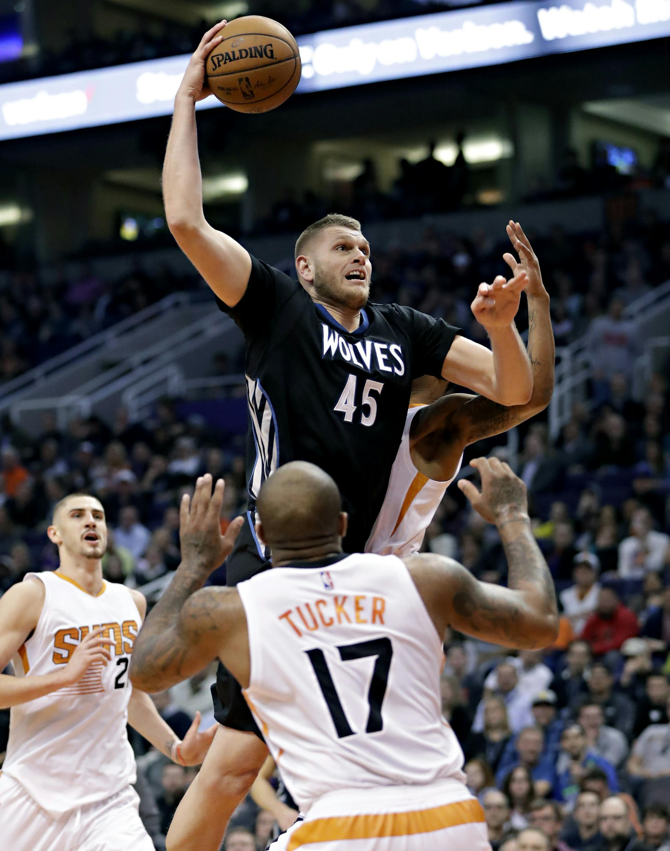Minnesota Timberwolves center Cole Aldrich (45) dunks over Phoenix Suns forward P.J. Tucker (17) during the first half of an NBA basketball game, Tuesday, Jan. 24, 2017, in Phoenix. (AP Photo/Matt York)