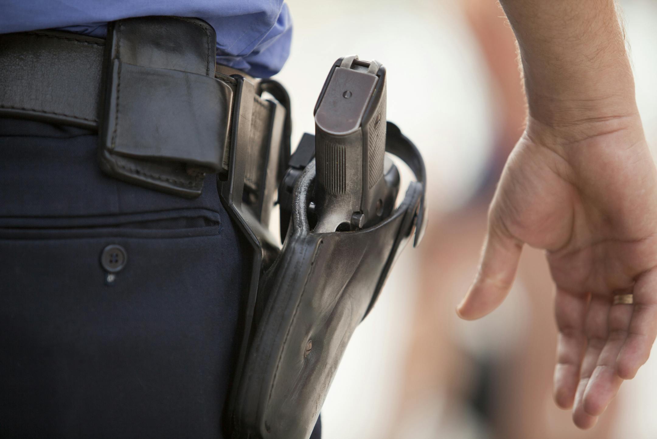 A policeman with his hand close to his gun.