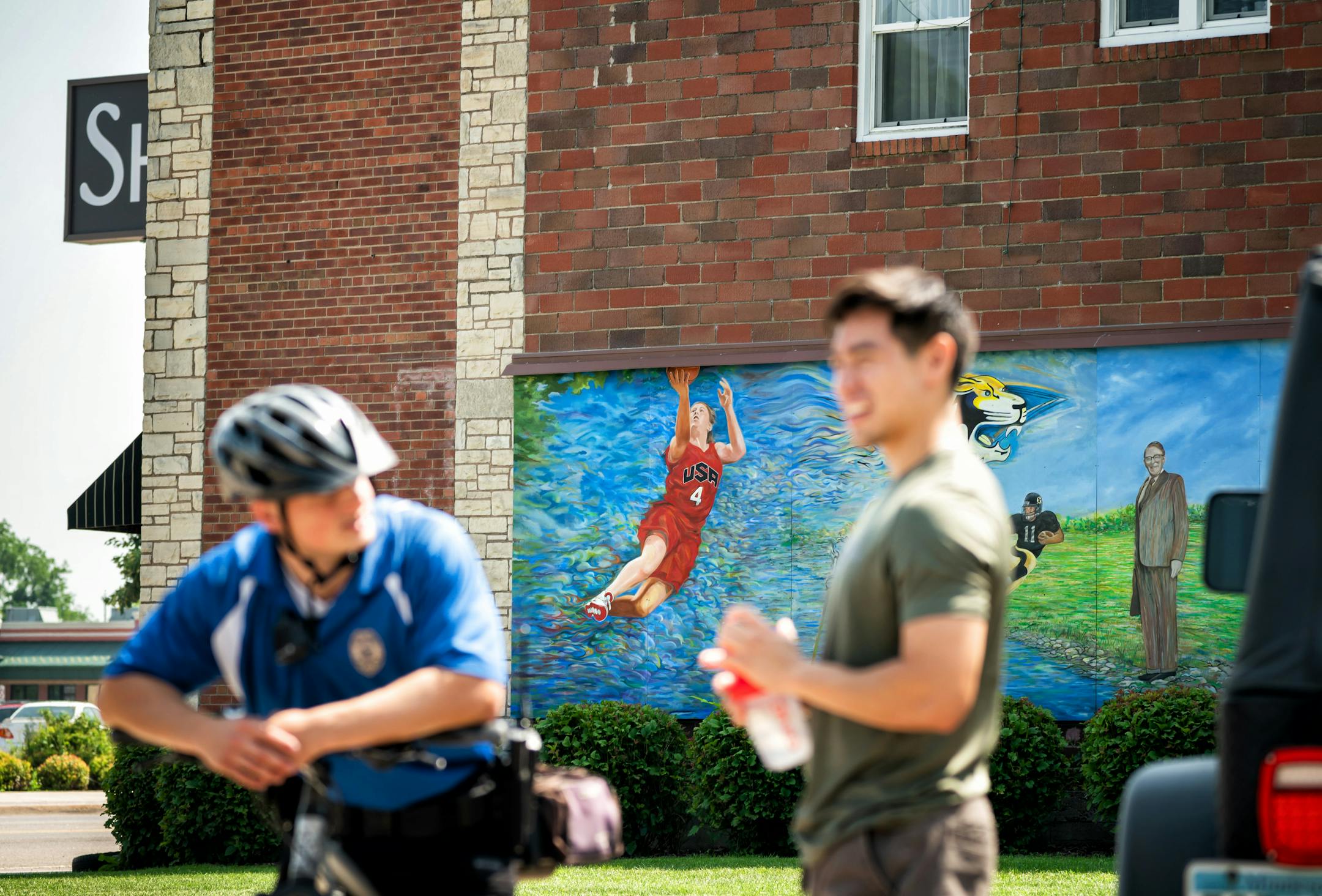 Park Police officer Tucker Gifferson and Juan Zamora talked next to the mural. Lindsay Whalen is part of a mural painted on the side of Security Coin & Pawn Shop in downtown Hutchinson.