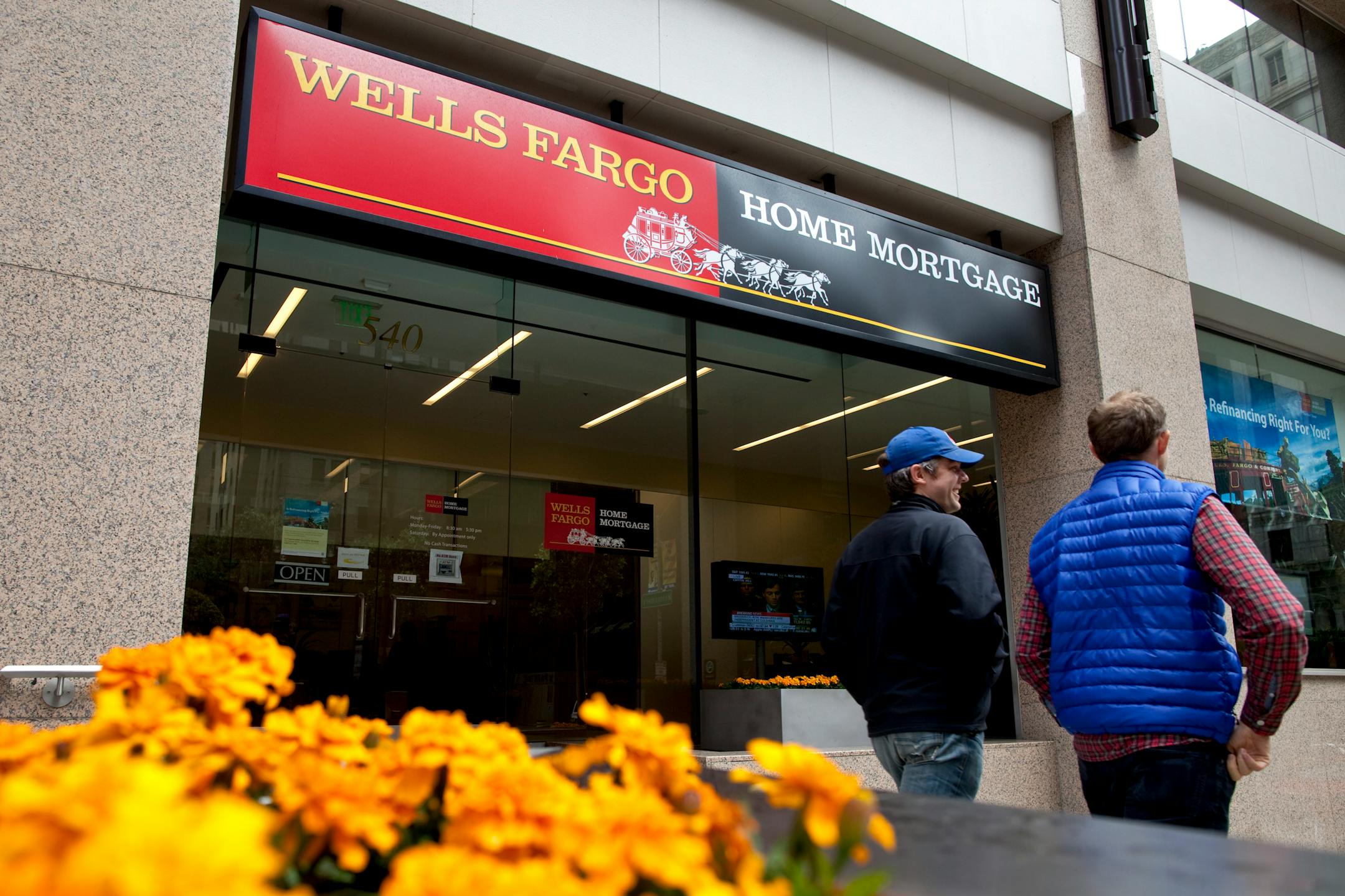 Pedestrians walk past a Wells Fargo & Co. Home Mortgage branch in San Francisco, California, U.S., on Tuesday, April 27, 2010. Wells Fargo & Co., the fourth-largest U.S. bank by assets and deposits, may raise its dividend once capital levels satisfy regulators and if the economic recovery continues, said Chief Executive Officer John Stumpf. Photographer: David Paul Morris/Bloomberg