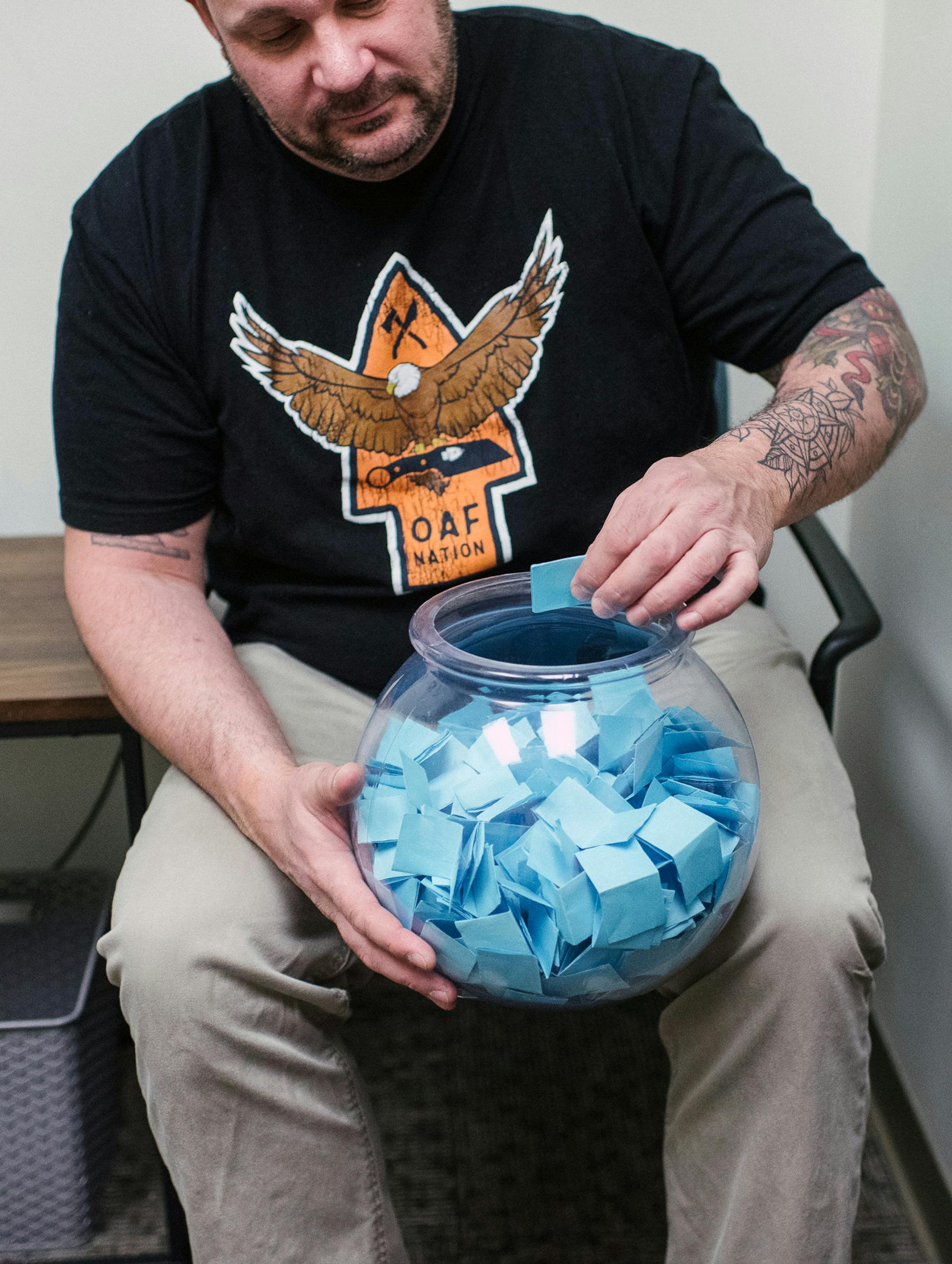 Stephen Goldschmidt draws a slip of paper from a bowl as part of his contingency management treatment at the Philadelphia Veterans Affairs Medical Center on March 4, 2020. Some slips offer encouraging messages; others, monetary rewards. (Hannah Yoon/The New York Times)