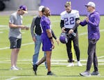 Vikings receiver Justin Jefferson, center, talks with coach Kevin O'Connell, right, at Jefferson's first spring workout with the team on Tuesday.