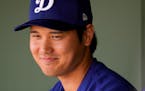 Los Angeles Dodgers designated hitter Shohei Ohtani in the dugout before a spring training game against the Texas Rangers, Wednesday, Feb. 28, 2024, i