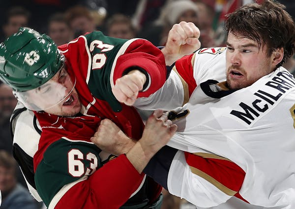 Kurtis Gabriel (63) and Dylan Mcilrath (8) fought in the first period during Tuesday night's game. ] CARLOS GONZALEZ cgonzalez@startribune.com - Decem
