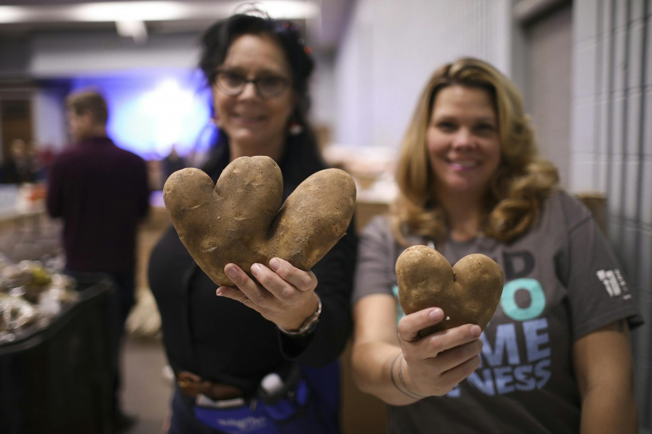 The goofy shapes you find when packaging potatoes for Thanksgiving meal bags at the Union Gospel Mission. Lonnie West, left, and Christy Vasquez held up a "W" (maybe?) and a heart-shaped potato while putting packaging potatoes.
