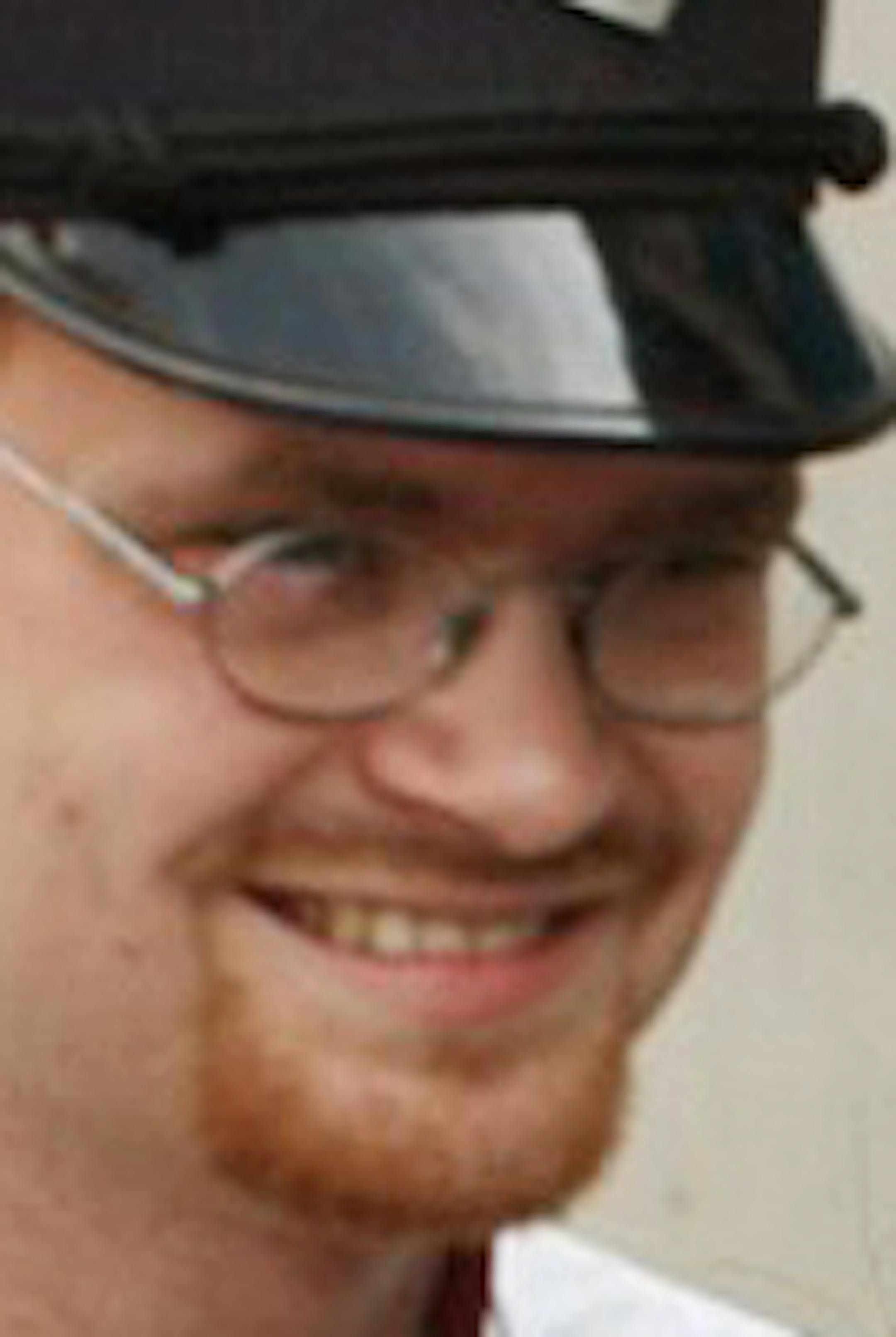 In this Aug. 21, 2007 photo, Amtrak assistant conductor, Brandon Bostian stands by as passengers board a train at the Amtrak station in St. Louis. Accident investigators said Wednesday that the engineer driving an Amtrak train wasn't using his cellphone in the moments before the train derailed in Philadelphia last month, deepening the mystery of what caused the accident. (Huy Richard Mach/St. Louis Post-Dispatch via AP) MANDATORY CREDIT