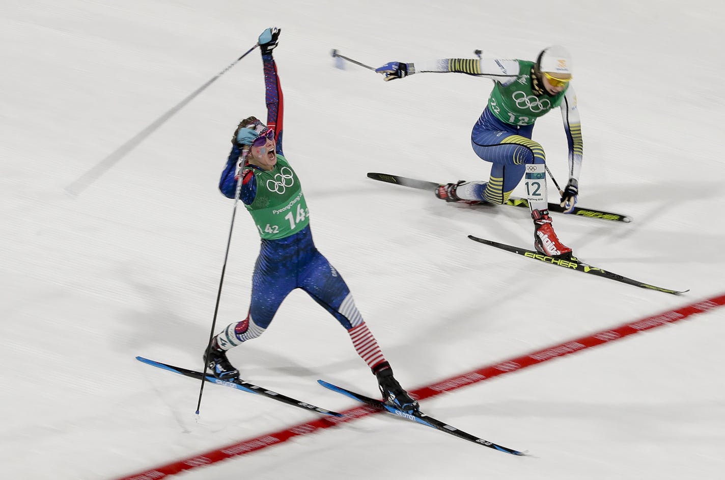 Jessica Diggins, left, of the United States, celebrates after winning the gold medal past Stina Nilsson, of Sweden, in the during women's team sprint freestyle cross-country skiing final at the 2018 Winter Olympics in Pyeongchang, South Korea, Wednesday, Feb. 21, 2018. (AP Photo/Dmitri Lovetsky)