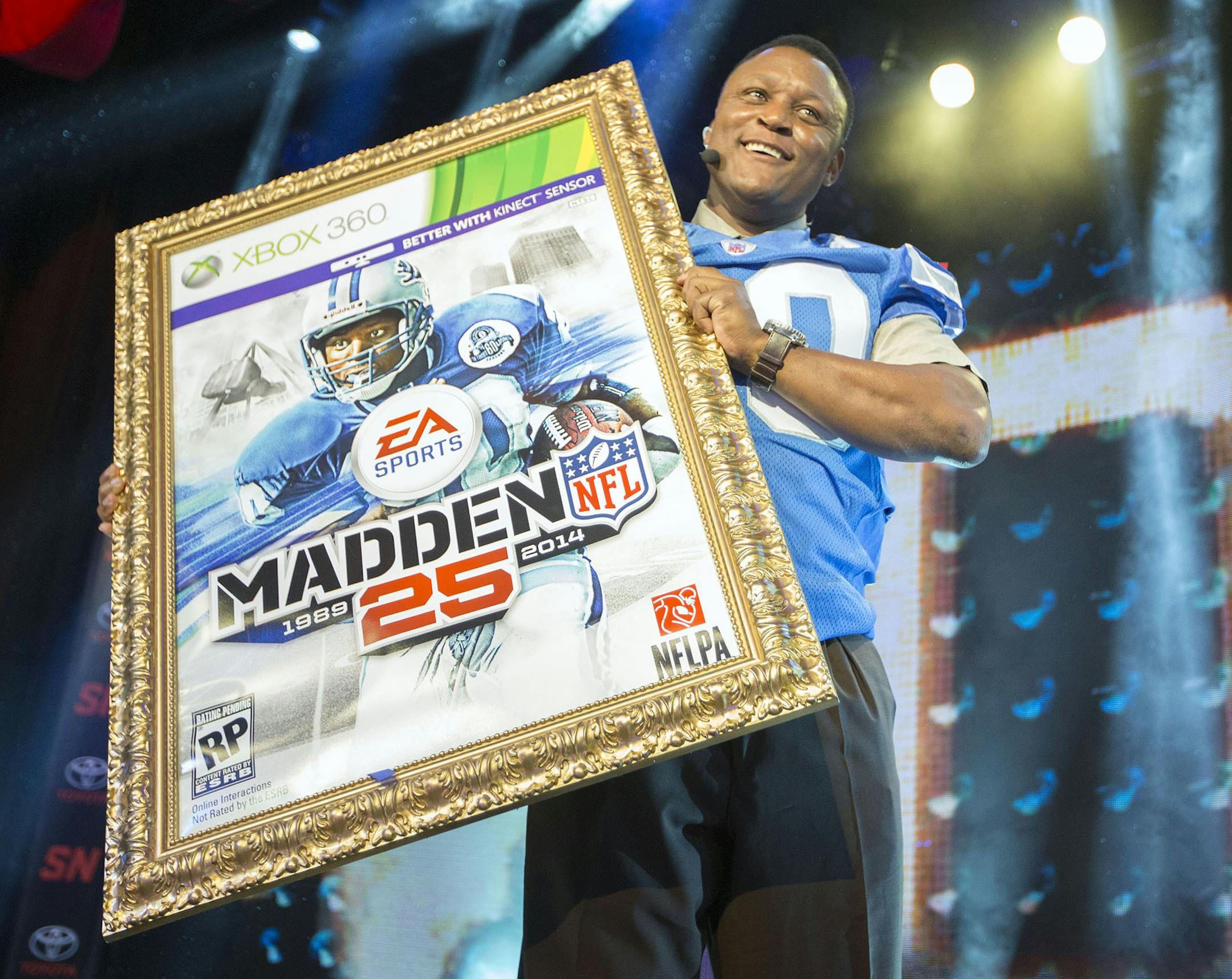 NFL hall of fame running back Barry Sanders holds up a mock up of the "Madden 25" video game cover during the EA Sports Madden NFL 25 Cover Reveal on SportsNation on Wednesday, April, 24, 2013 in New York, New York. (Photo by Chris Park/Invision for EA Sports/AP Images) ORG XMIT: INVL