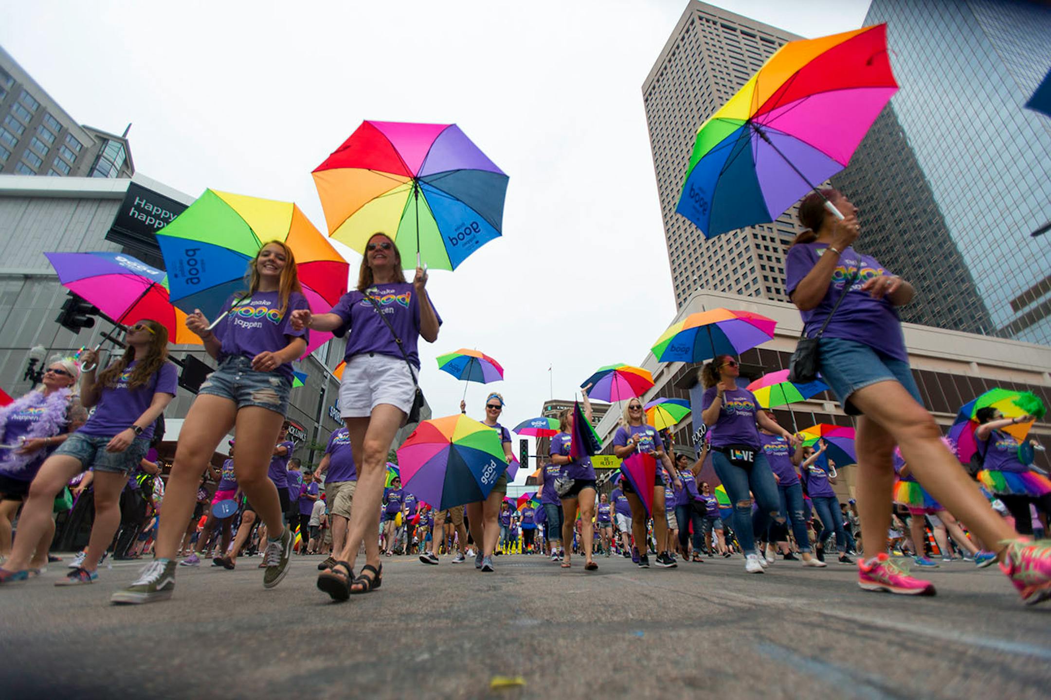 Dozens of people marched in the pride parade carrying rainbow colored umbrellas on Sunday.