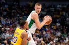 Los Angeles Lakers guard Avery Bradley (20) as Dallas Mavericks center Kristaps Porzingis, right, looks for an opening to the basket in the first half