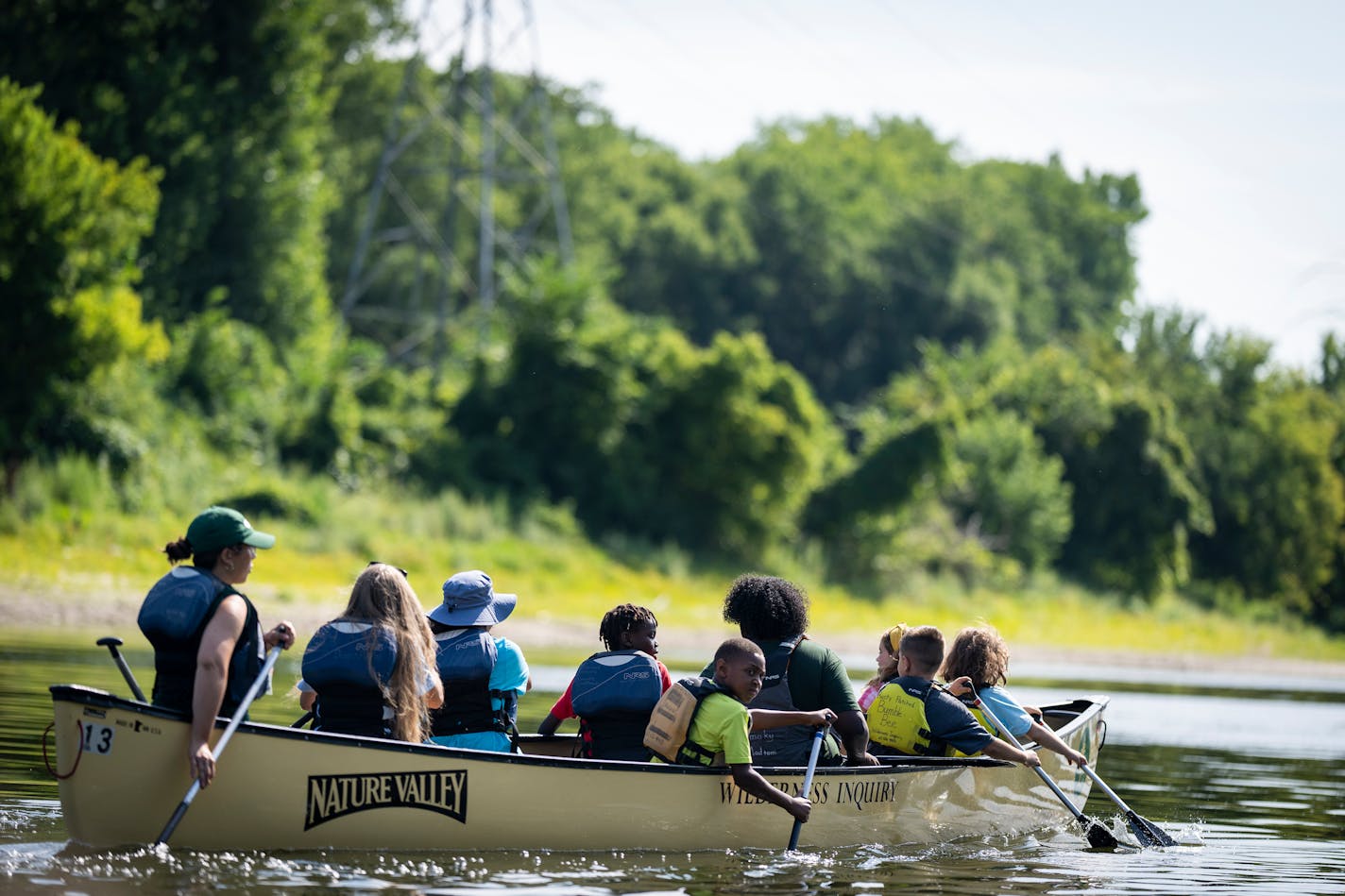 Campers paddle during a short canoe trip on the Mississippi River from Hidden Falls Regional Park to Crosby Farm Regional Park during YMCA Adventure in the Neighborhood day camp.