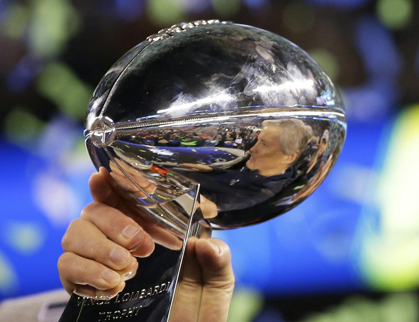 Seattle Seahawks head coach Pete Carroll is reflected in the Vince Lombardi Trophy after the NFL Super Bowl XLVIII football game against the Denver Broncos Sunday, Feb. 2, 2014, in East Rutherford, N.J. The Seahawks won 43-8. (AP Photo/Matt Slocum) ORG XMIT: MIN2014032817060242