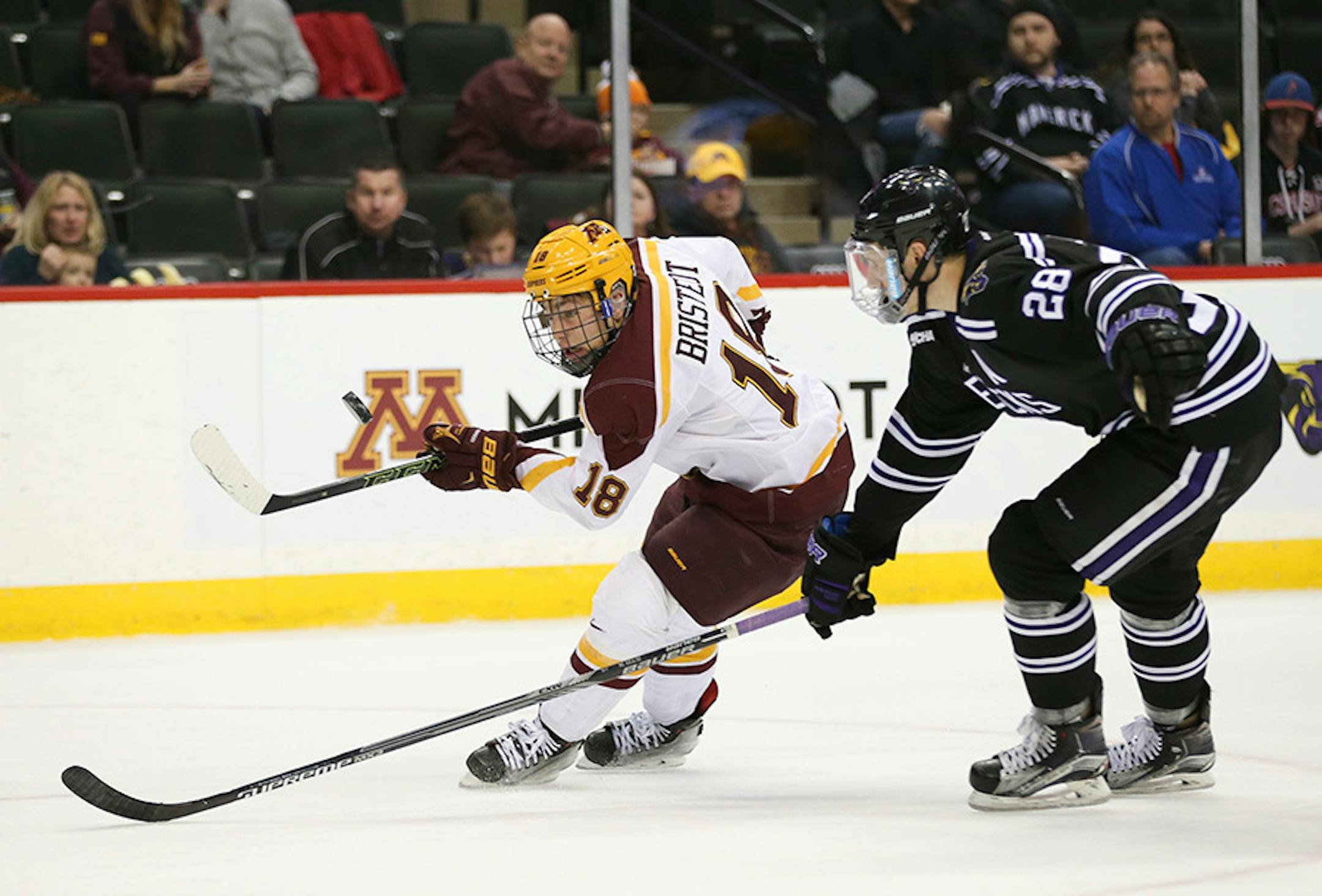 Gophers forward Leon Bristedt (18) took control of an airborne puck in front of Mavericks defenseman Jon Jutzi (28)in the third period Sunday afternoon.