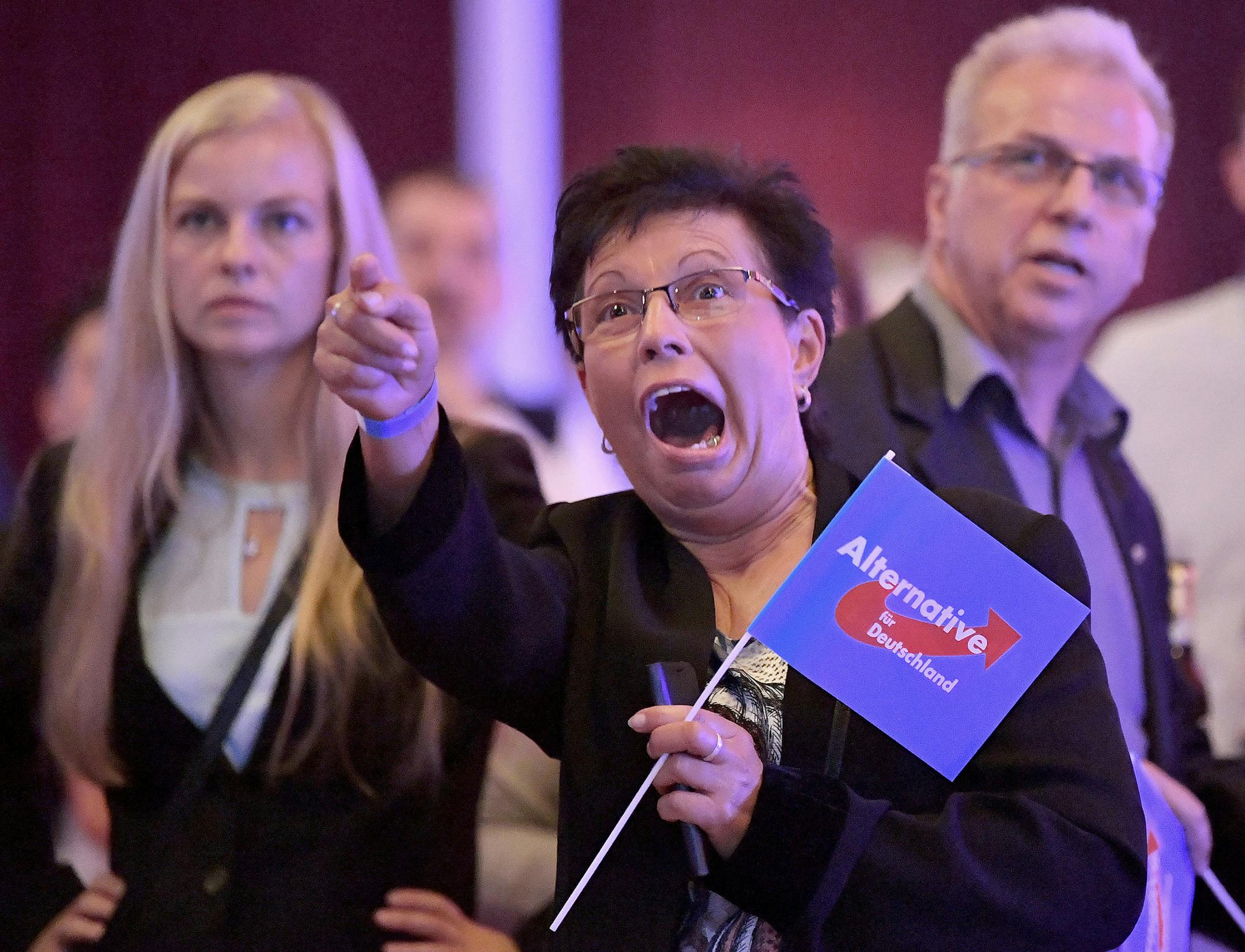 Guests at an Alternative for Germany party, AfD, election party react to the first projections for the German election in Erfurt, Germany, Sunday, Sept. 24, 2017. (Martin Schutt/dpa via AP) ORG XMIT: MIN2017092512472220