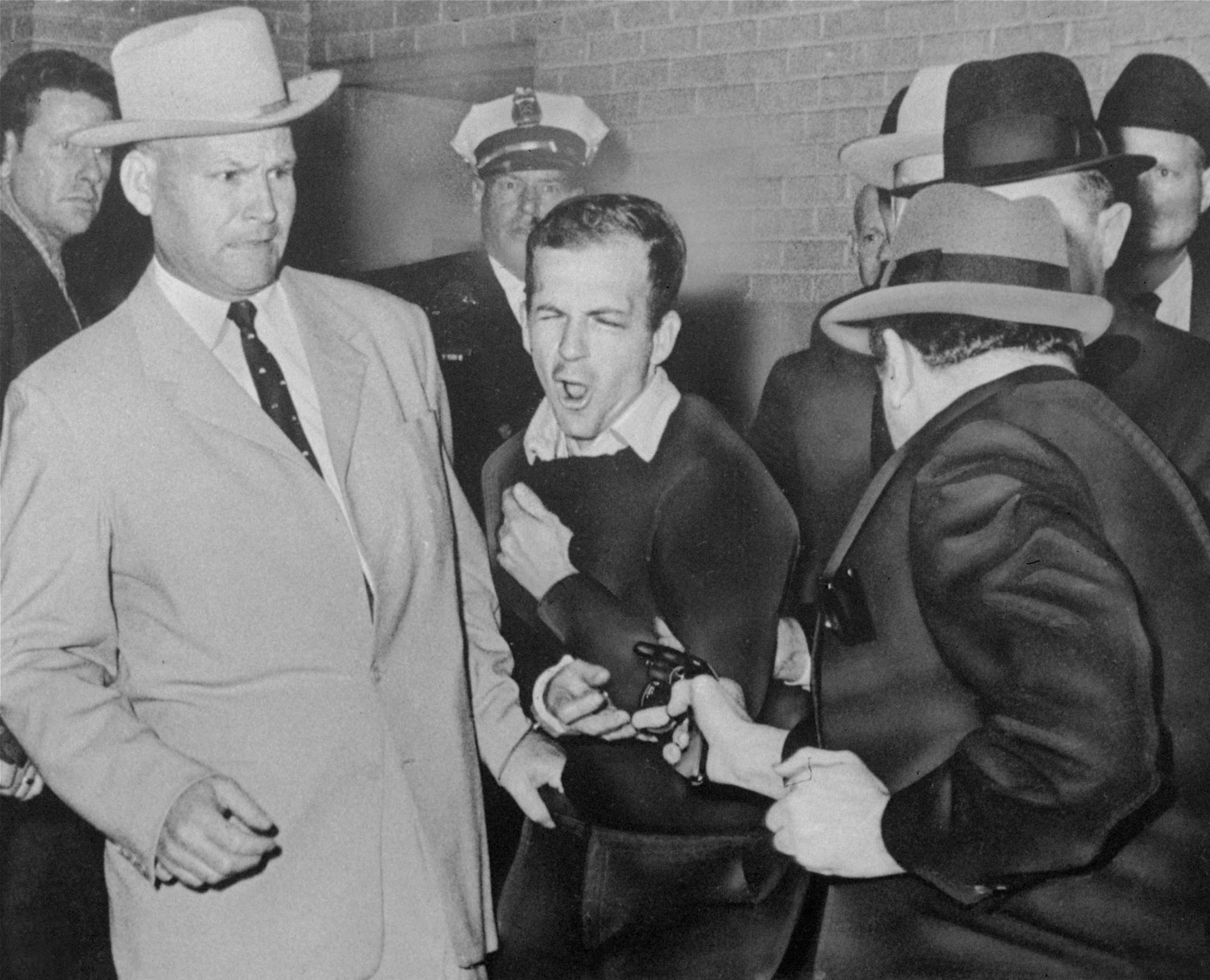Lee Harvey Oswald, accused assassin of President John F. Kennedy, reacts as Dallas night club owner Jack Ruby, foreground, shoots at him from point blank range in a corridor of Dallas police headquarters, in this Nov. 24, 1963 file photo. Plainclothesman at left is Jim A. Leavelle.