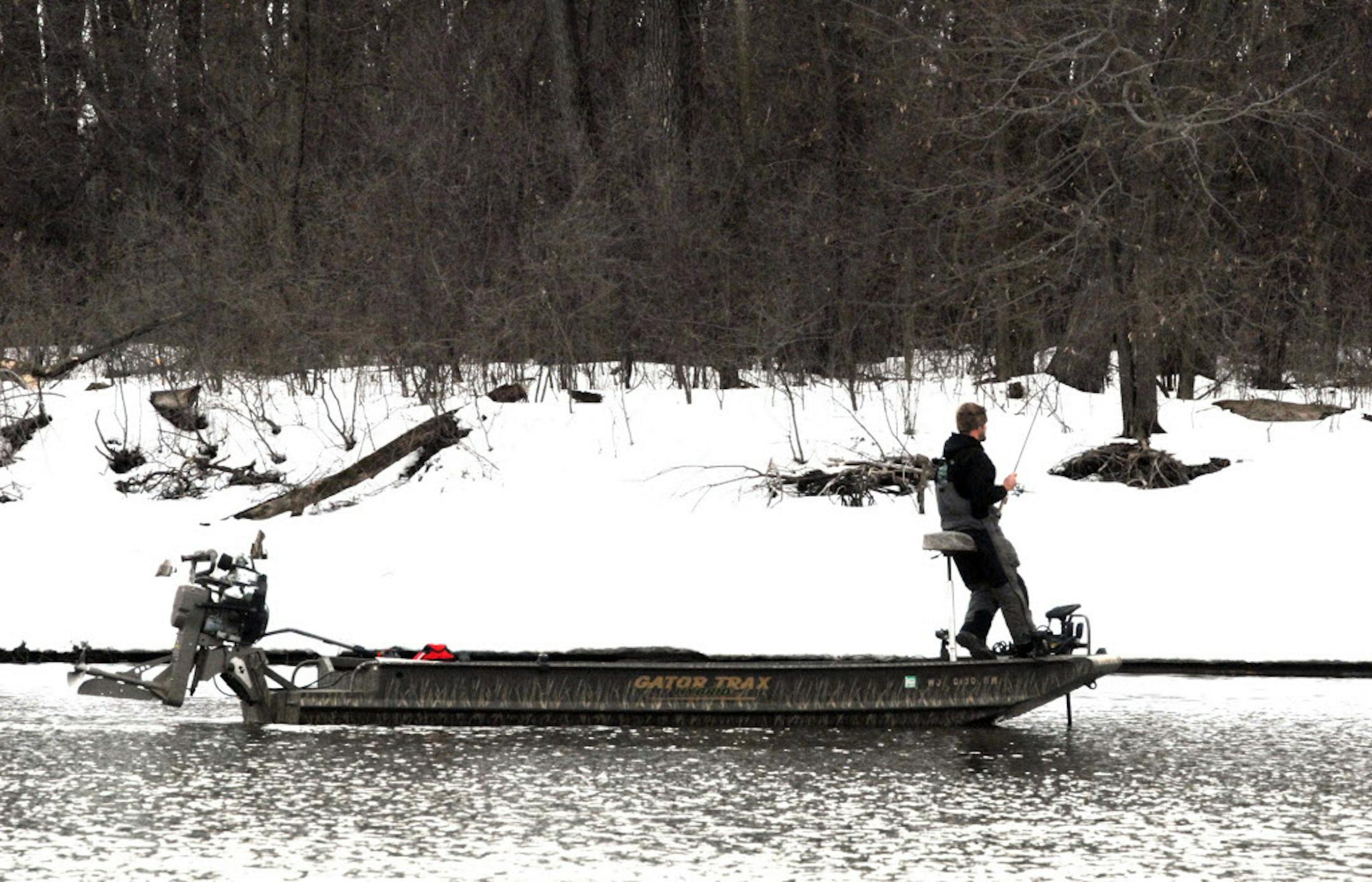 In a shallow-running boat rigged with a surface-drive outboard, an angler pitches his bait toward shore, looking for walleyes.