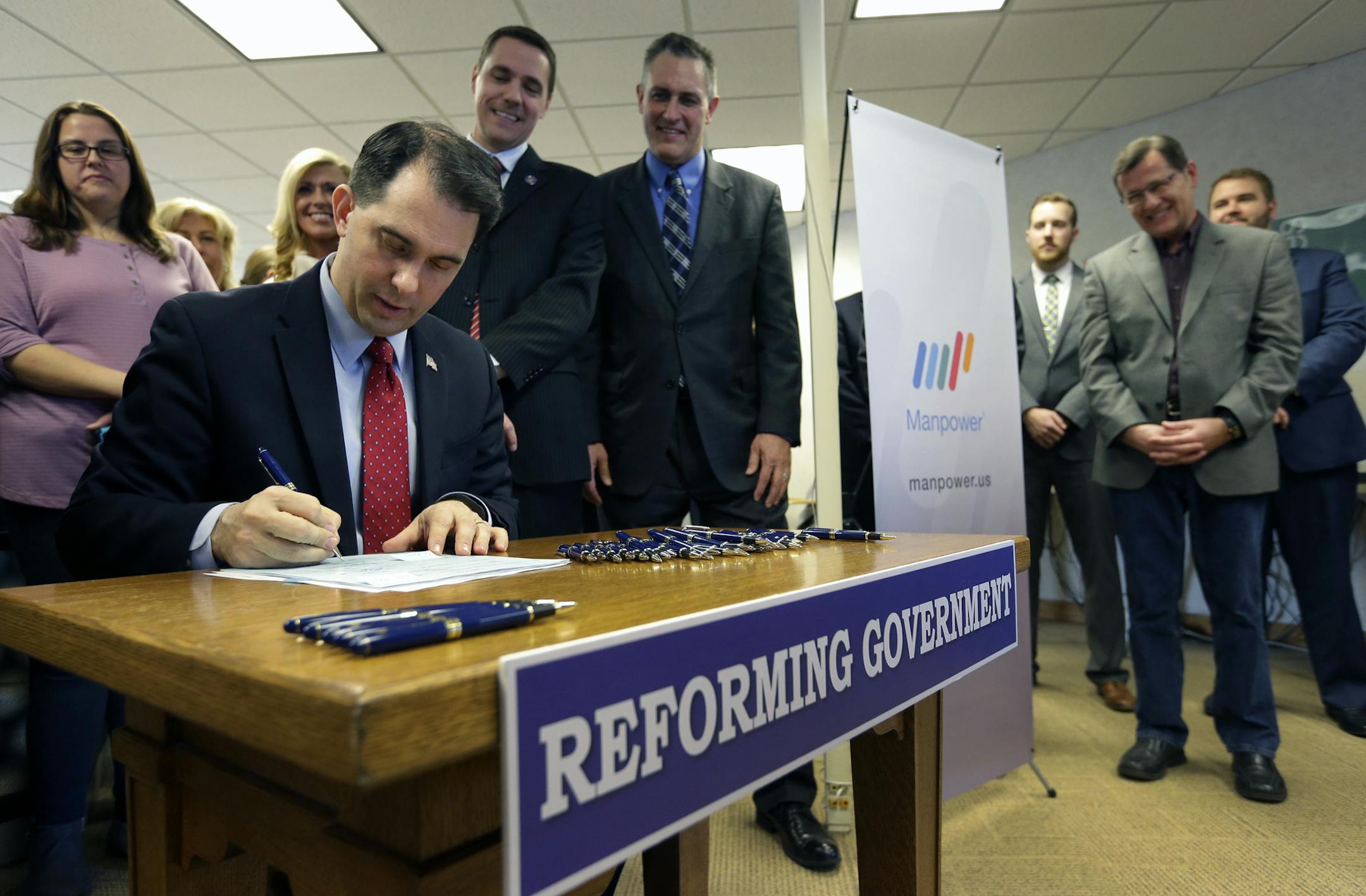 Wisconsin Gov. Scott Walker signs Assembly Bill 373 Friday, Feb. 12, 2016, at Manpower Group in Appleton, Wis. (Dan Powers /The Post-Crescent via AP) NO SALES; MANDATORY CREDIT