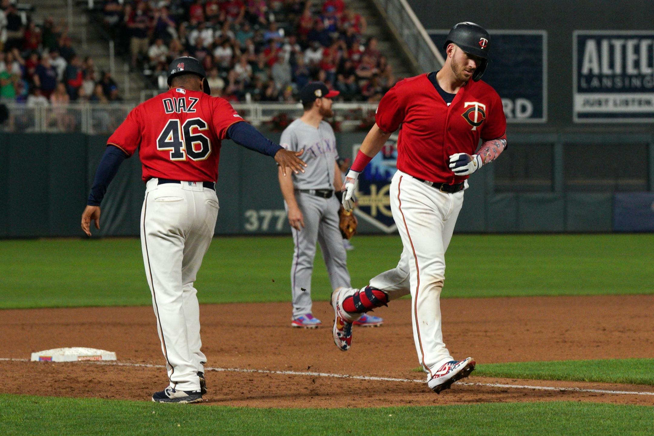 Minnesota Twins catcher Mitch Garver (18) celebrated with Minnesota Twins third base coach Tony Diaz (46) after hitting a home run in the seventh inning.