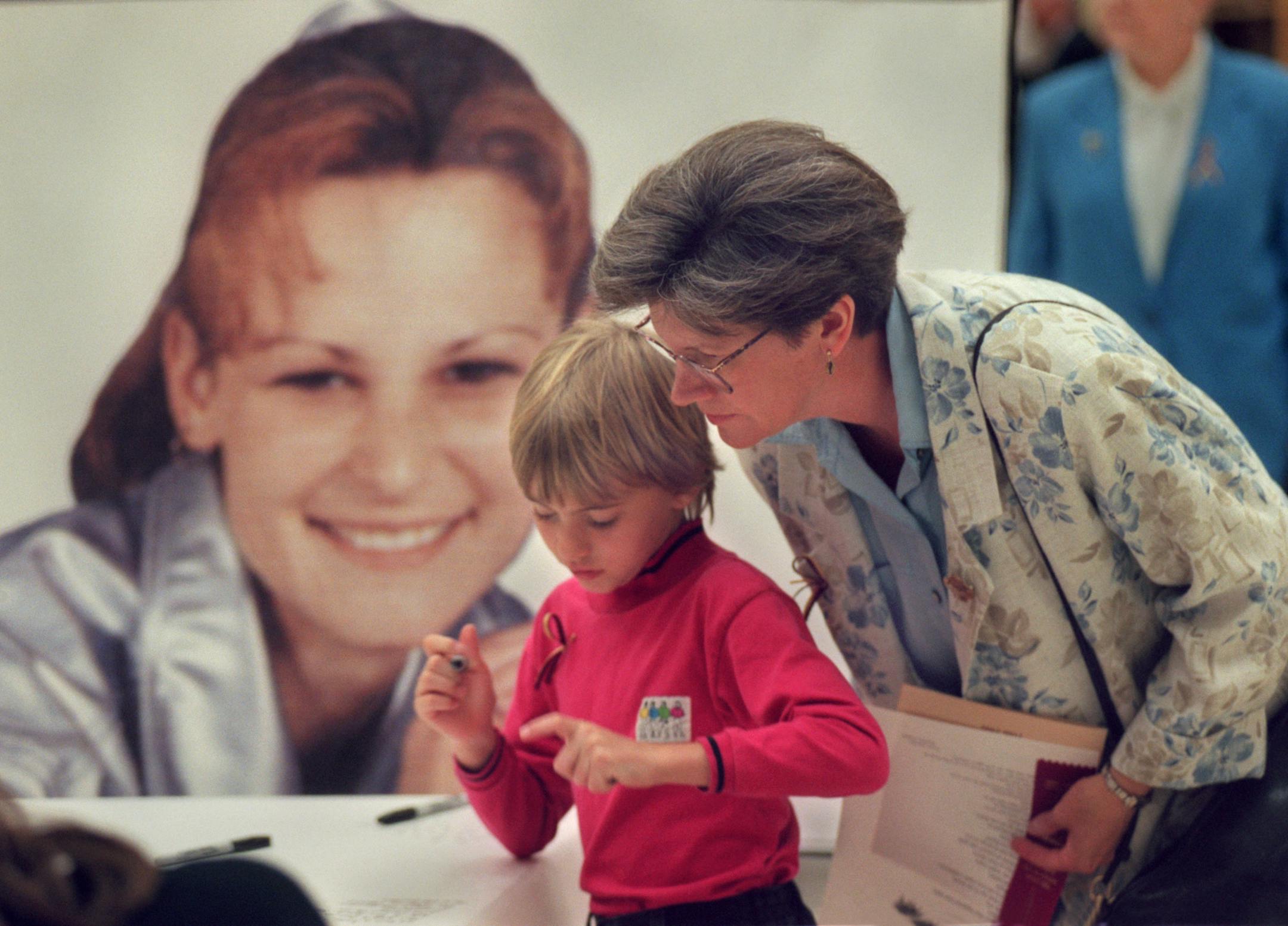 Katie Fleckenstein and her mom, the Rev. Cheryl Fleckenstein, wrote their thoughts on a memory scroll during a celebration of Katie Poirier's life at Barnum High School in1999.