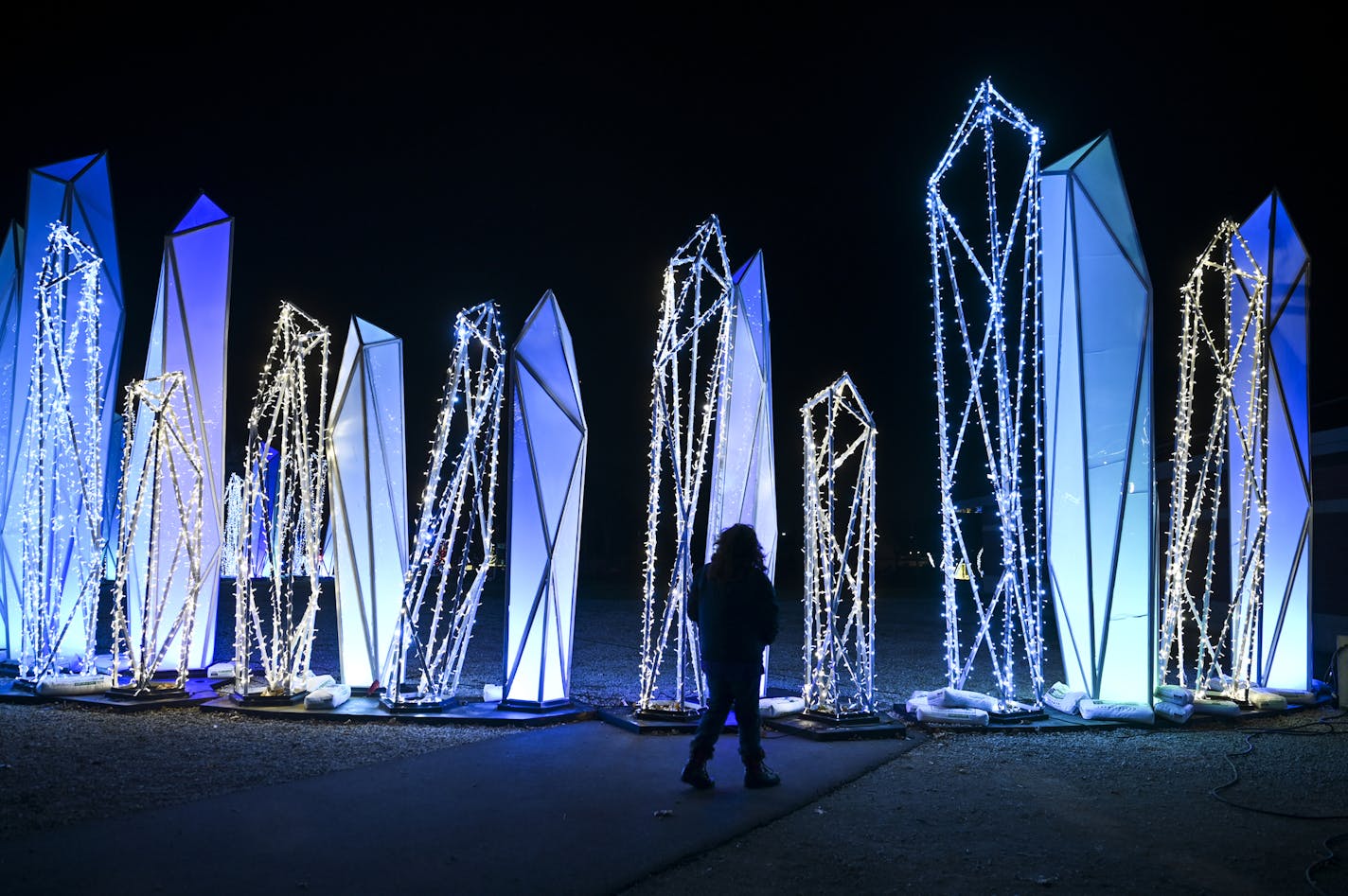 Molly Steinke, who is working public relations for the GLOW Holiday Festival, walked near the "Crystal Palisade" Wednesday night. ] AARON LAVINSKY • aaron.lavinsky@startribune.com Drive-through is the name of the entertainment game this fall and winter. The GLOW Holiday Light event at the state fairgrounds is just one of the new breed of holiday light shows coming onboard in 2020. We photograph the GLOW Holiday Festival on Wednesday, Nov. 18, 2020 in Falcon Heights, Minn.