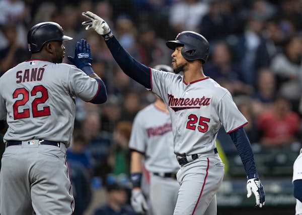 Minnesota Twins' Byron Buxton, right, is congratulated by Miguel Sano after hitting a three-run home run off of starting pitcher Erik Swanson that sco