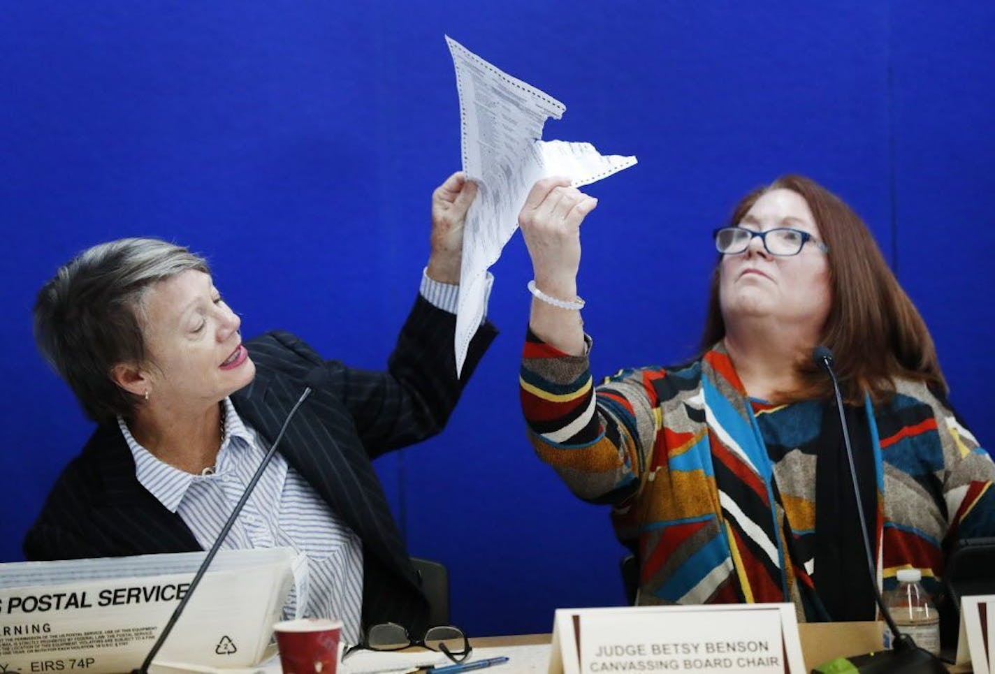 Canvassing Board chair Judge Betsy Benson, left, and board member Judge Deborah Carpenter-Toye, right, show political lawyers one of the ballots that was damaged during the recount that will need to be duplicated and then recounted, at the Broward County Supervisor of Elections office during a recount, Wednesday, Nov. 14, 2018, in Lauderhill, Fla.