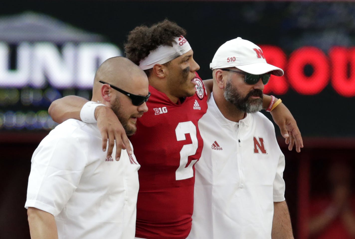 Nebraska trainers help injured quarterback Adrian Martinez (2) off the field during the second half of an NCAA college football game against Colorado in Lincoln, Neb., Saturday, Sept. 8, 2018. Colorado won 33-28. (AP Photo/Nati Harnik)