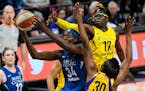 Minnesota Lynx center Sylvia Fowles (34) powered through the defense of Los Angeles Sparks forward Essence Carson (17) and forward Nneka Ogwumike (30)