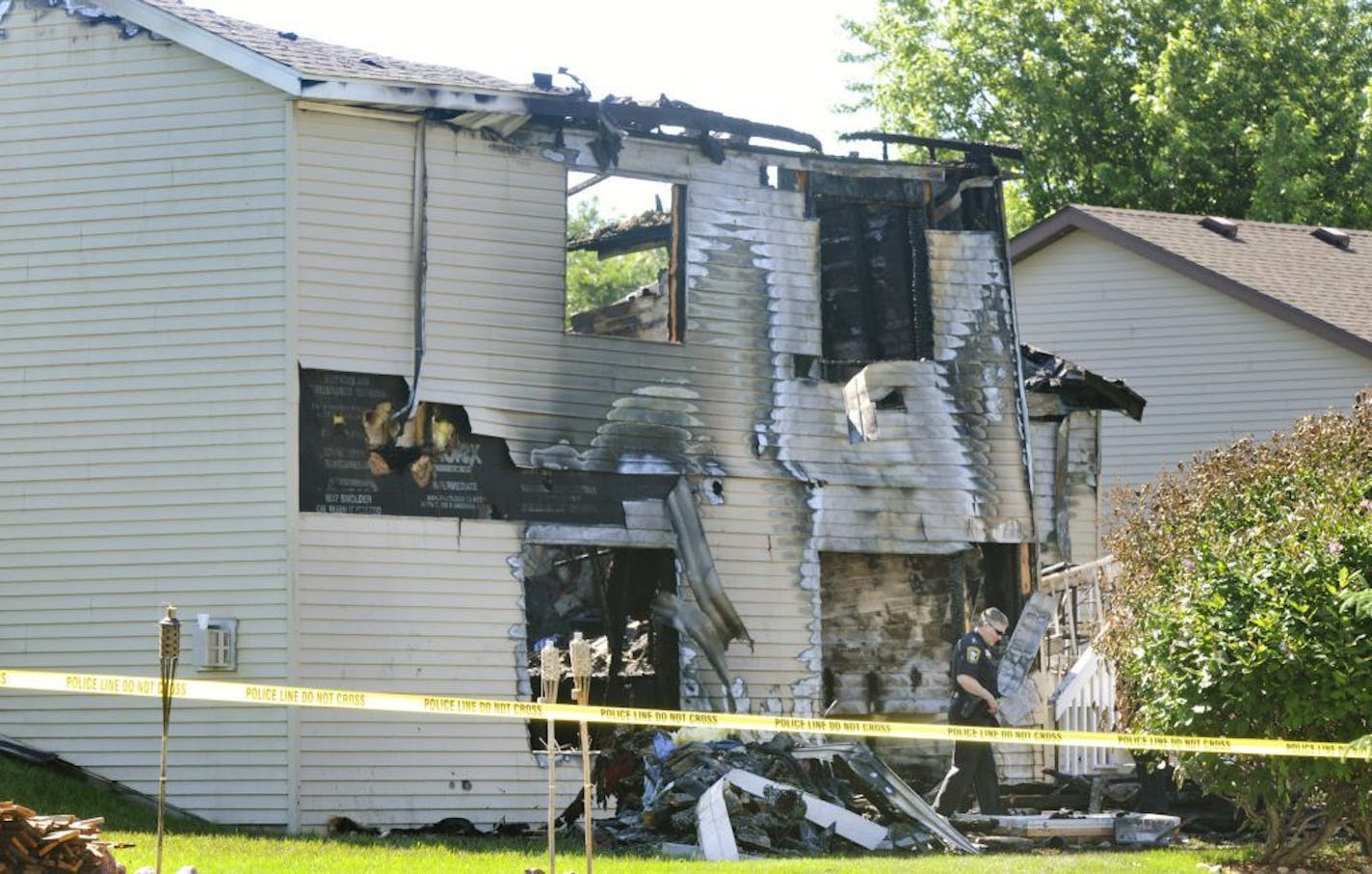 June 21, 2014: Police officers keep people away from the scene where a small plane crashed into a home in Sauk Rapids, killing the pilot and passenger and setting the home ablaze.