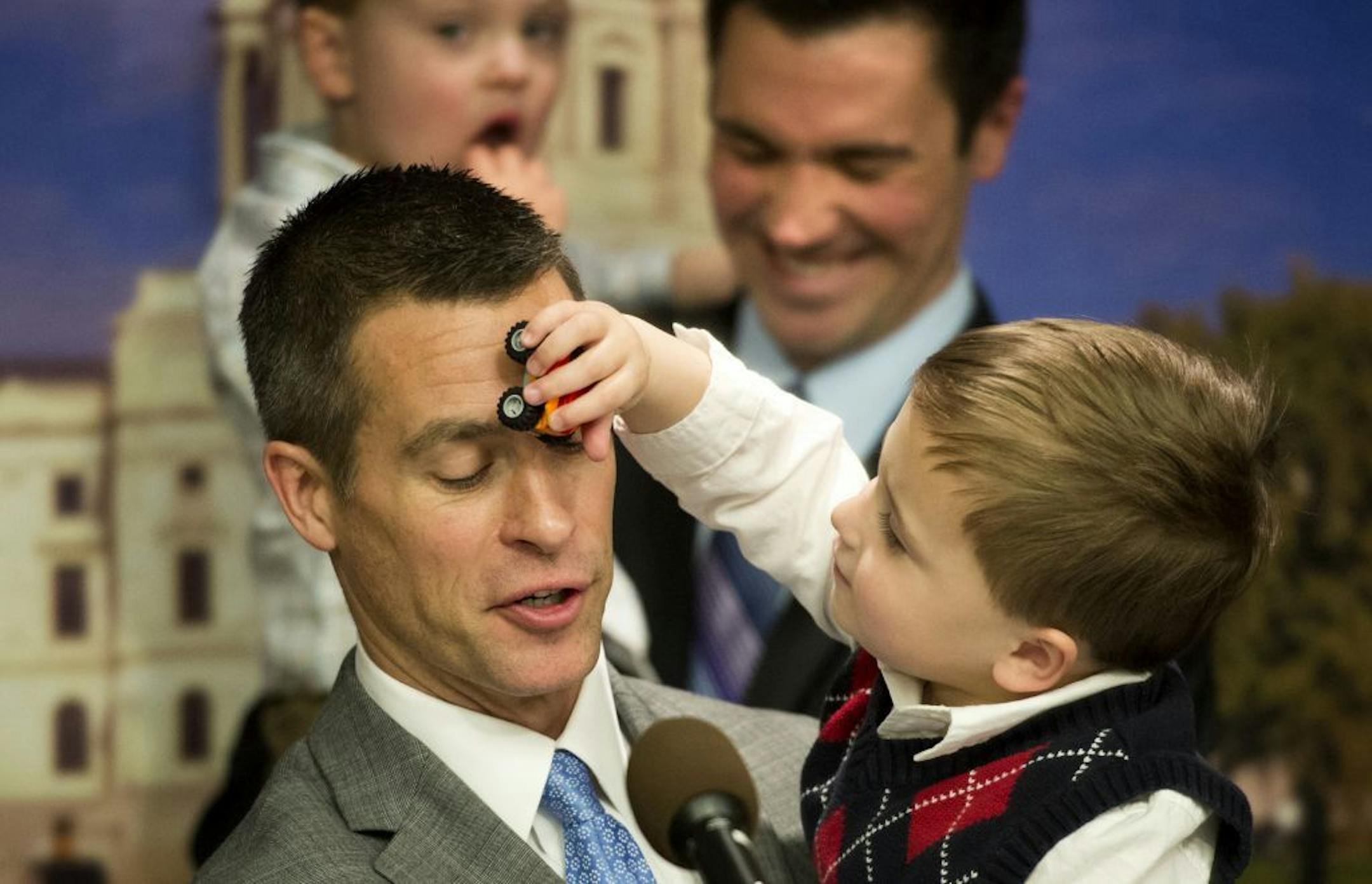 Dr. Paul Melchert got an unexpected car across the face from son Emmett while he spoke at the news conference. Behind him is husband James Zimmerman with the couple's other son Gabriel. Surrounded by same-sex couples and their children, Senator Scott Dibble and Rep. Karen Clark introduced their bill to legalize same-sex marriages in Minnesota. Wednesday, February 27, 2013.