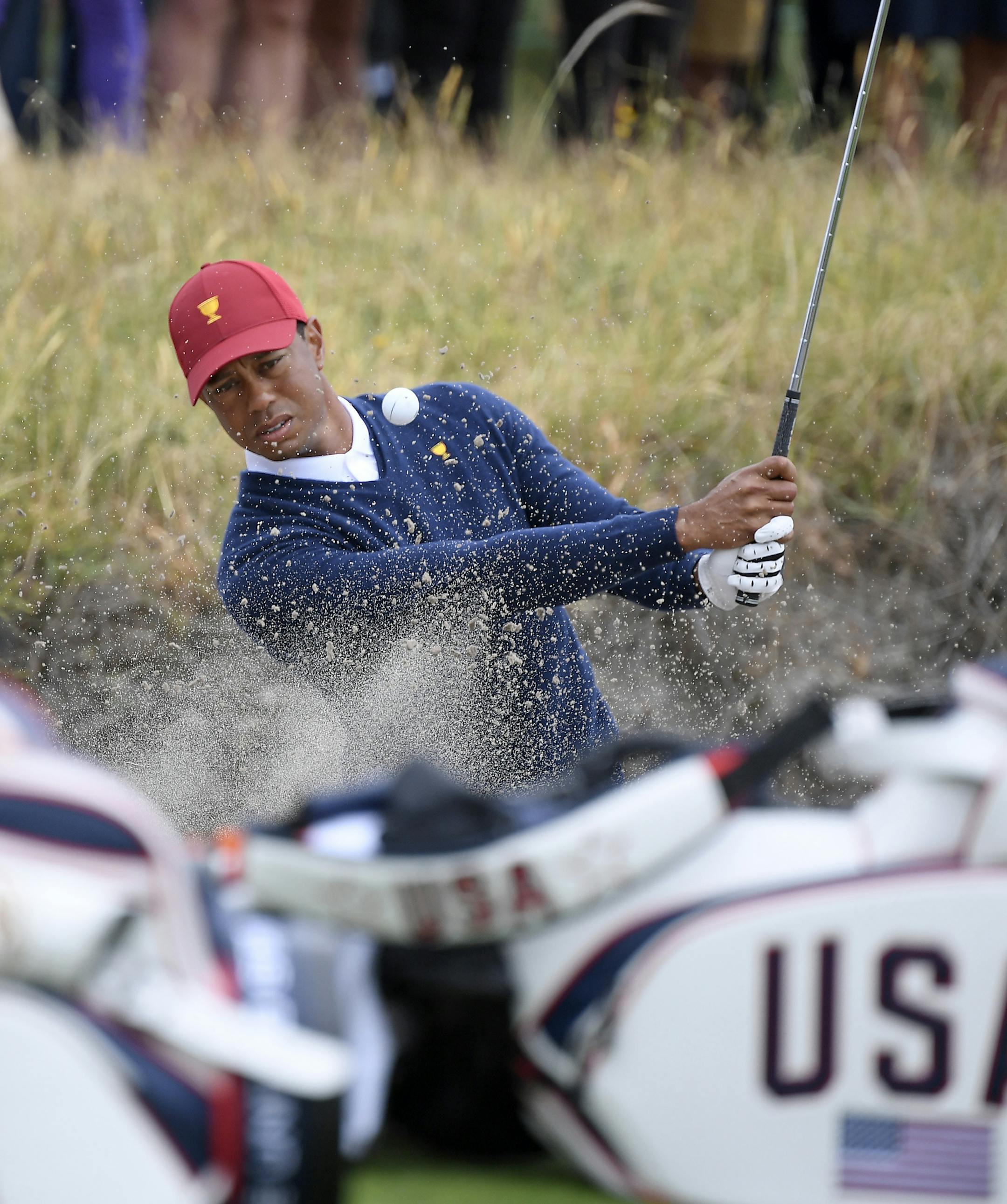 USA captain Tiger Woods hits out of a bunker during a practice session ahead of the President's Cup Golf tournament in Melbourne, Tuesday, Dec. 10, 2019. (AP Photo/Andy Brownbill)