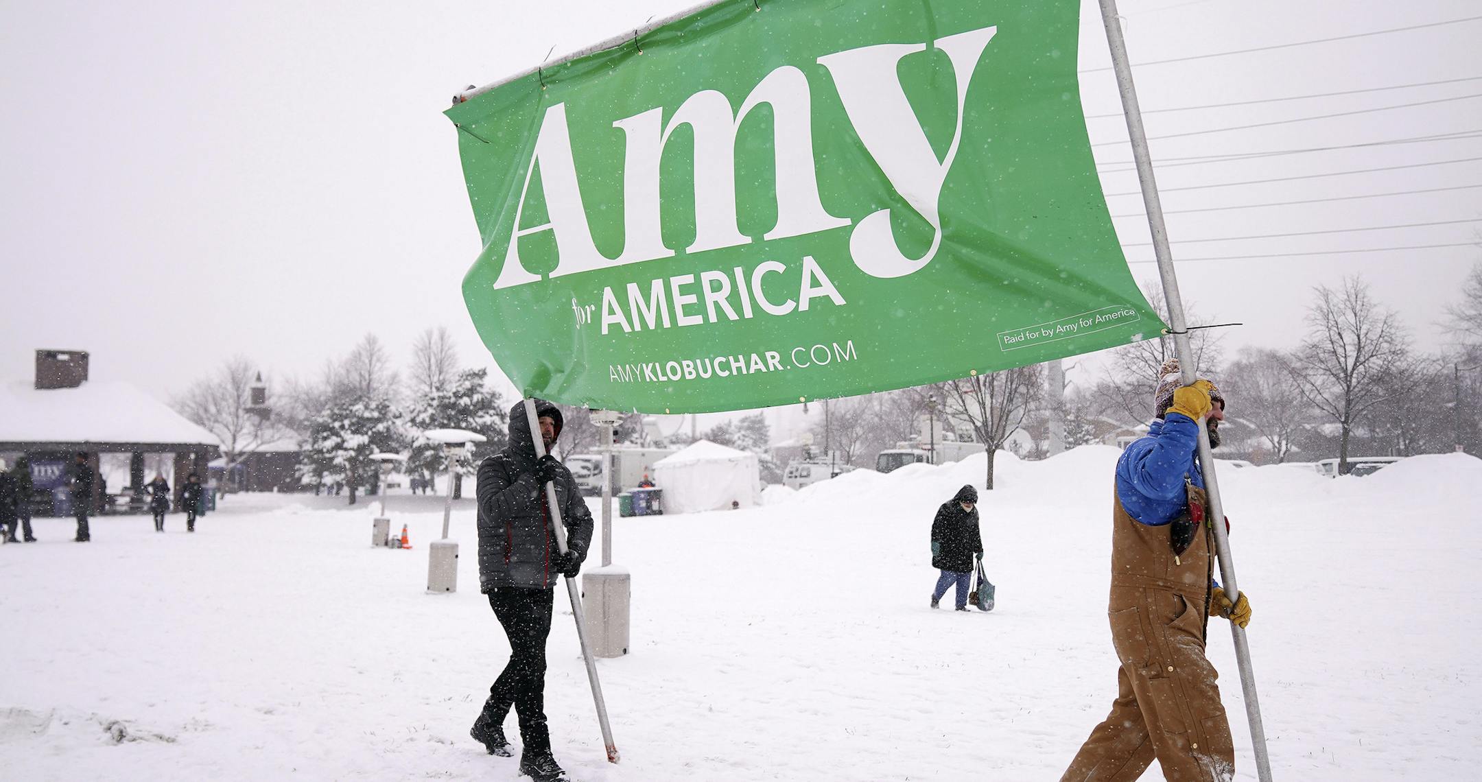Volunteers Tim Schumann, left, and Chase Cushman move an "Amy for America" sign into place Sunday, Feb. 10, 2019, prior to Democratic Sen. Amy Klobuchar's announcement of her decision in the race for president at a rally in Minneapolis. (Anthony Souffle/Star Tribune via AP)