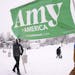Volunteers Tim Schumann, left, and Chase Cushman move an "Amy for America" sign into place Sunday, Feb. 10, 2019, prior to Democratic Sen. Amy Klobuch