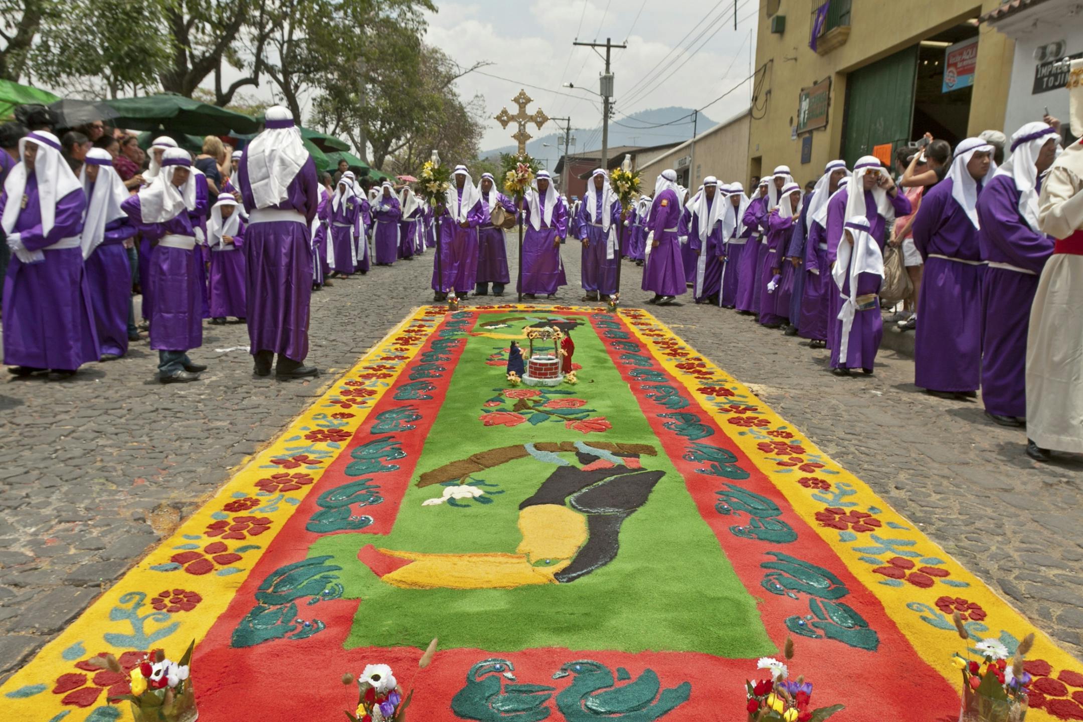 The last moments of this elaborate street carpet, called an alfombra, which was made by meticulously arranging colored sawdust into an intricate design. Seconds later this alfombra was trampled under the feet of the faithful during a Semana Santa procession in Antigua, Guatemala.